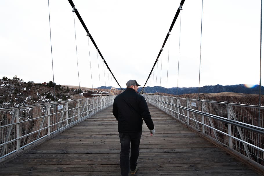 HD Wallpaper Man Wearing Cap Walking Along Bridge Adventure