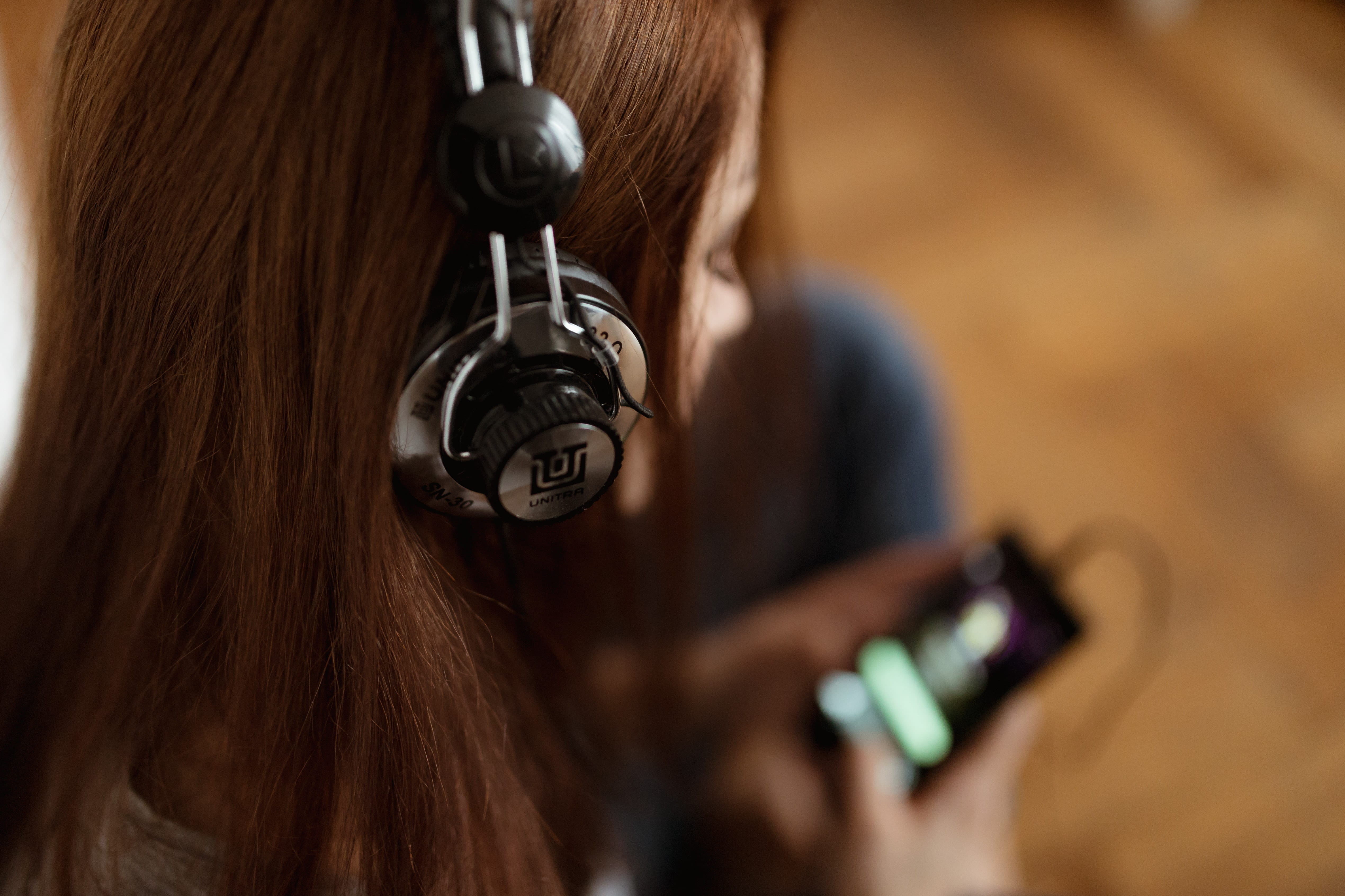 Beautiful young woman in headphones listening to music, adult