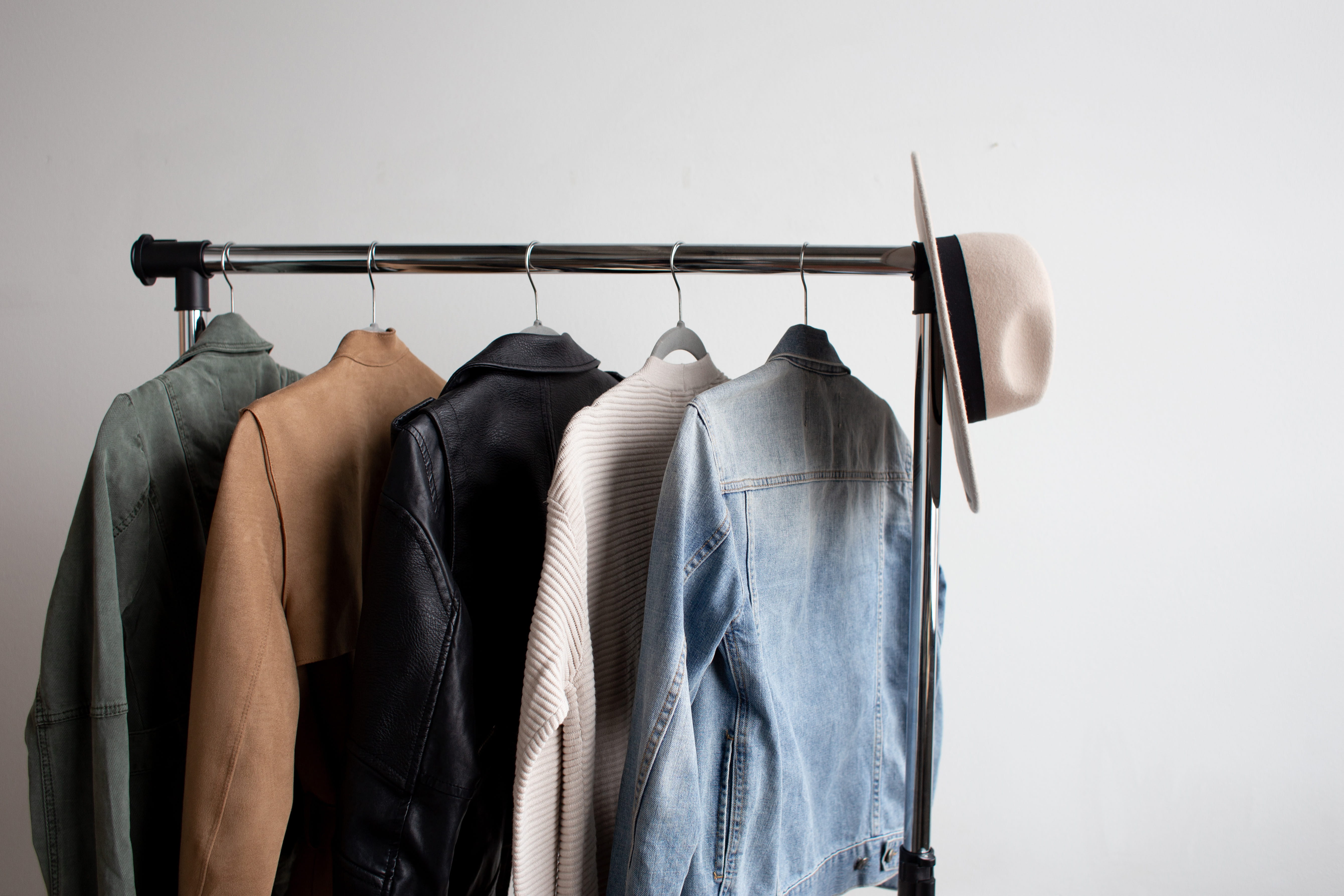 one cowboy hat and five jackets hanged on clothes rack, clothing