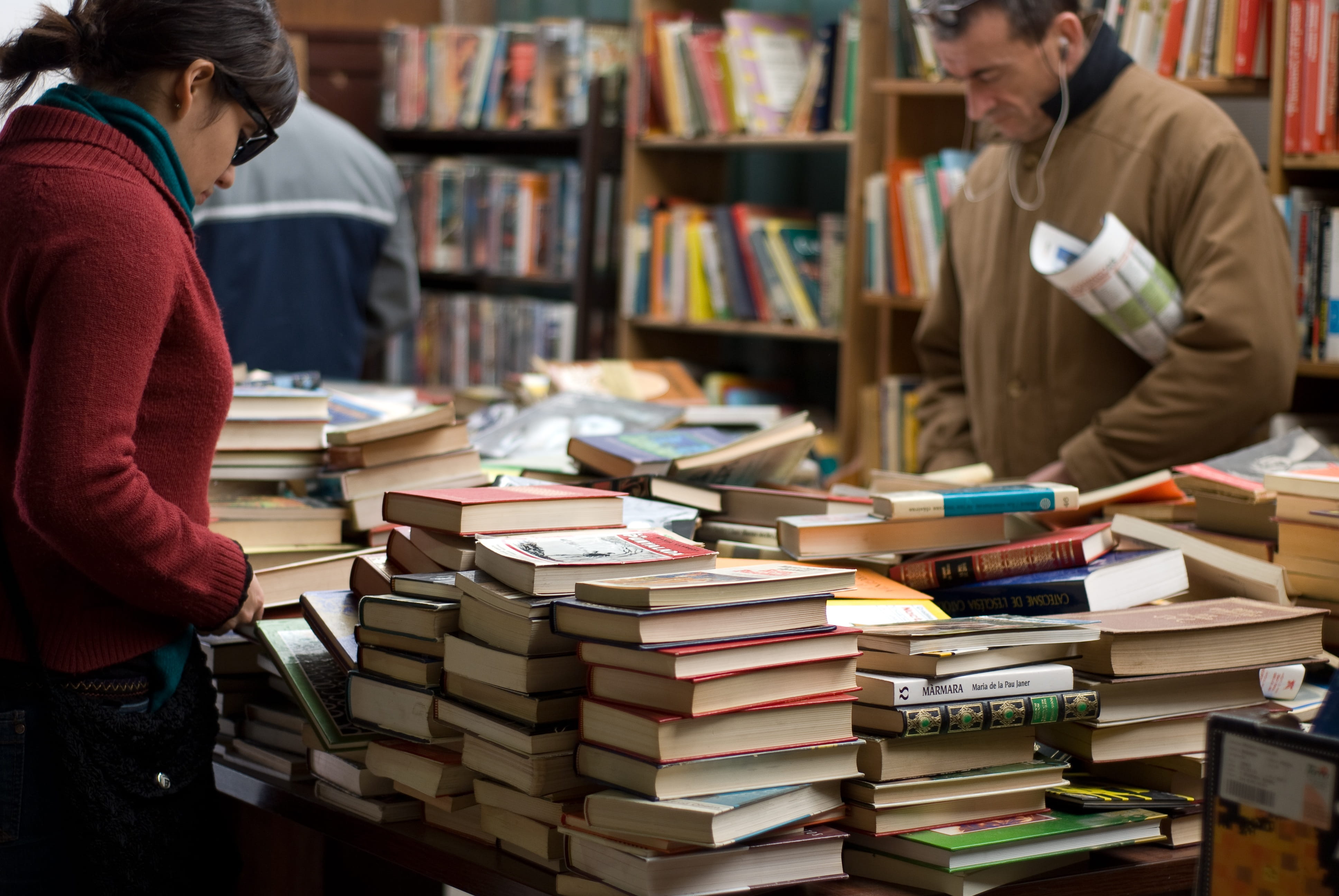 Woman and Man Standing Beside Piles of Books, adult, book store