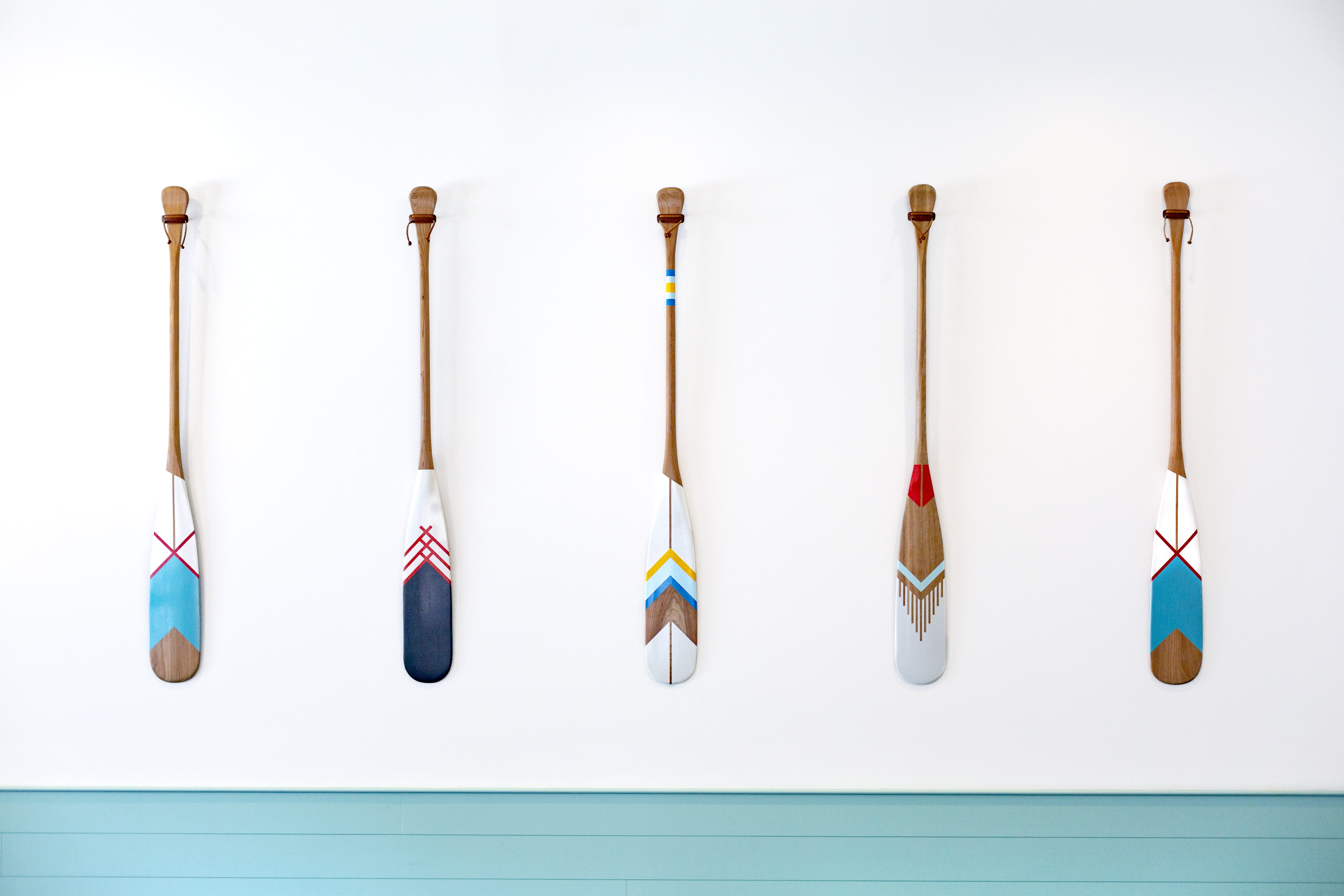 five assorted-color oars on white wall, paddle, hang, art, paint