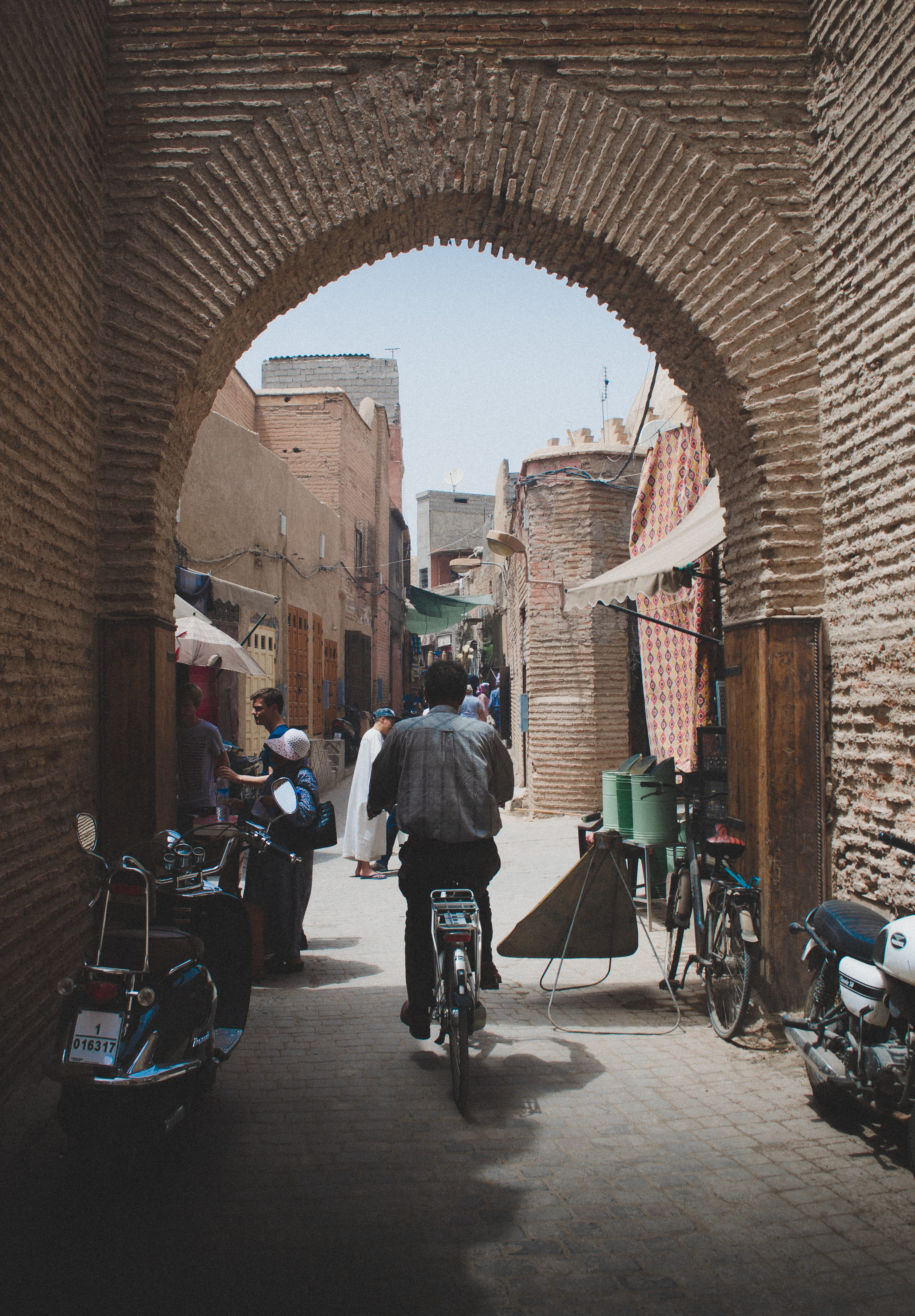man driving bicycle under archway, architecture, built structure