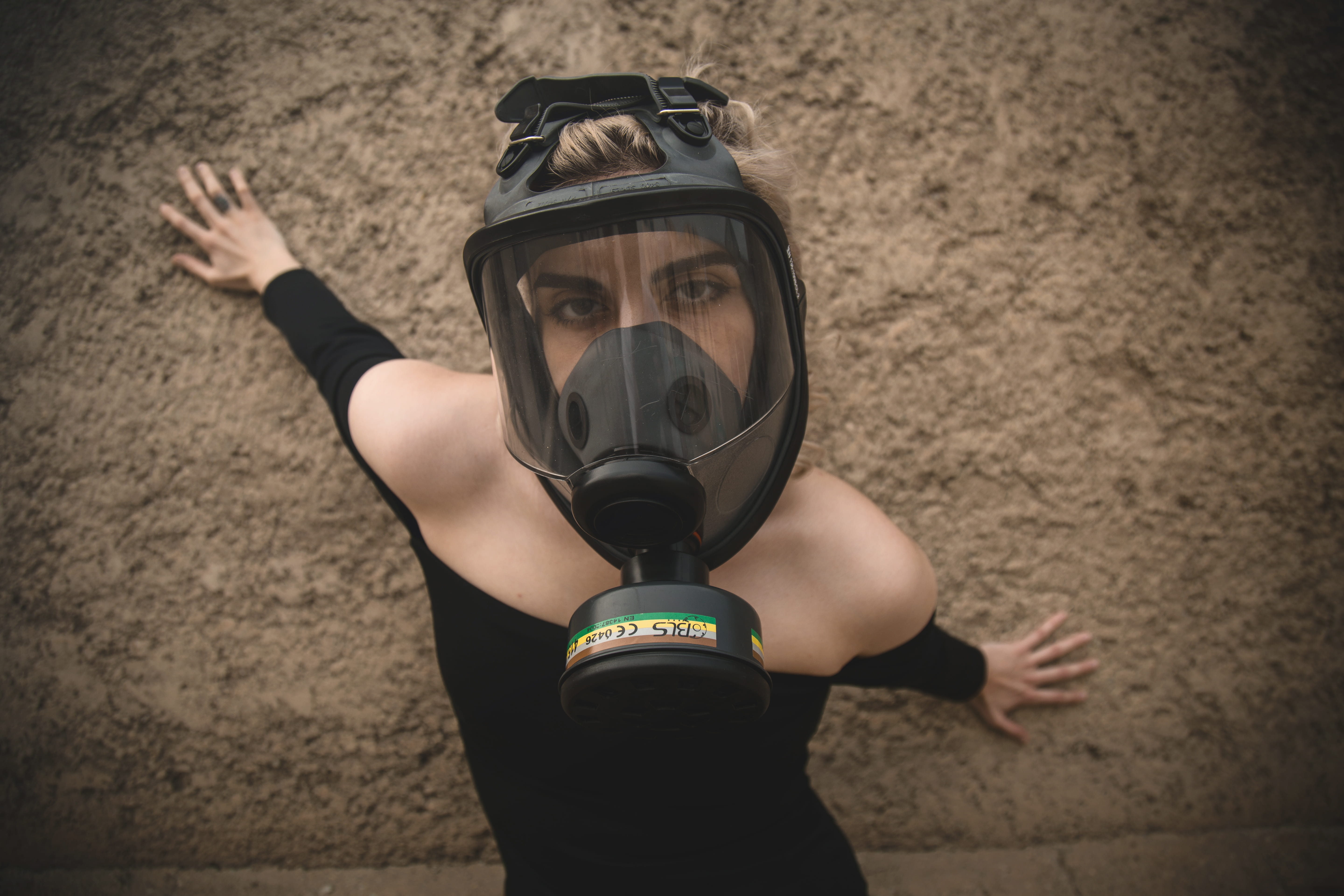 woman wearing black off-shoulder long-sleeved dress and black respirator mask