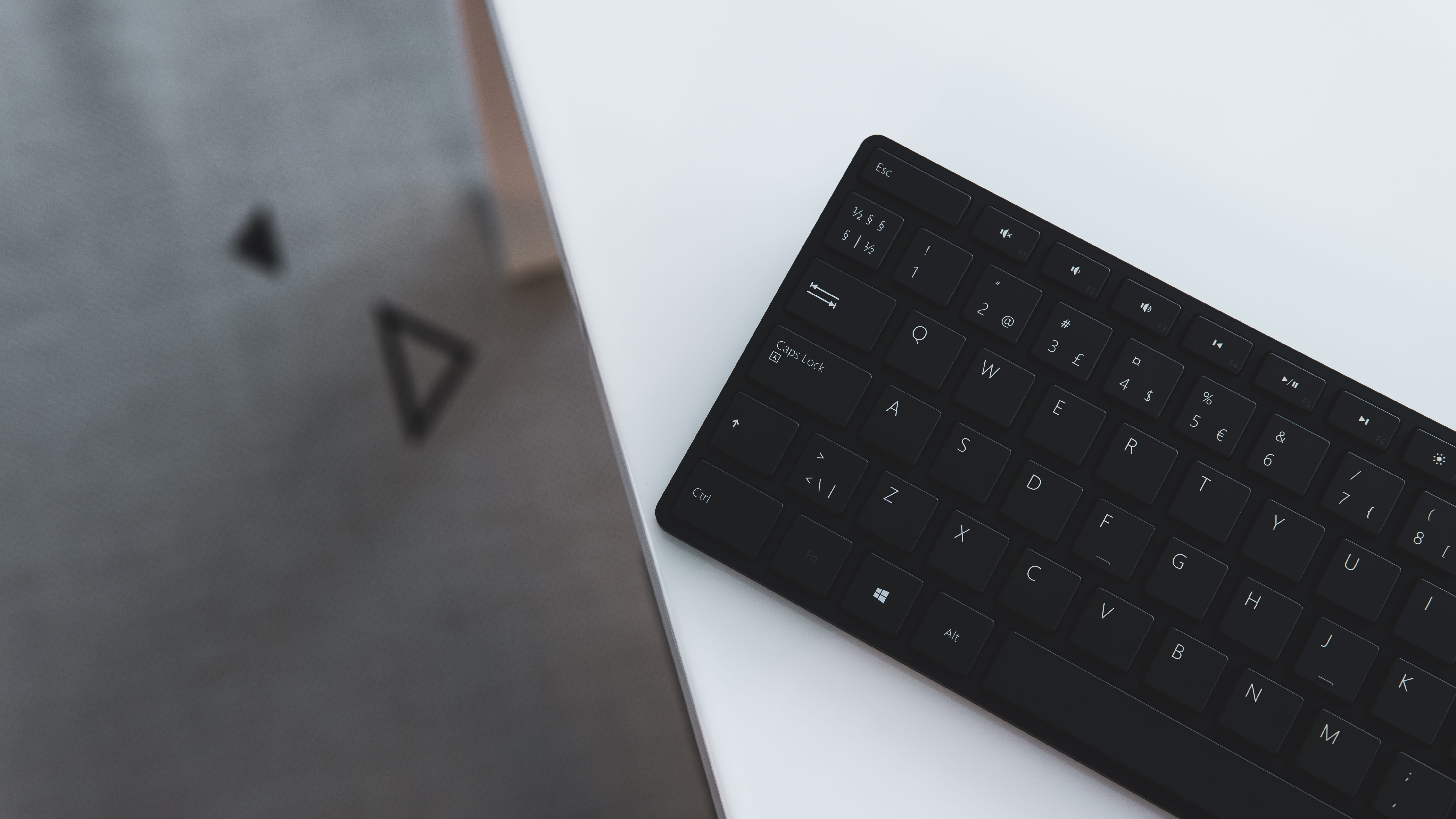 black wireless keyboard on white surface, hardware, computer hardware