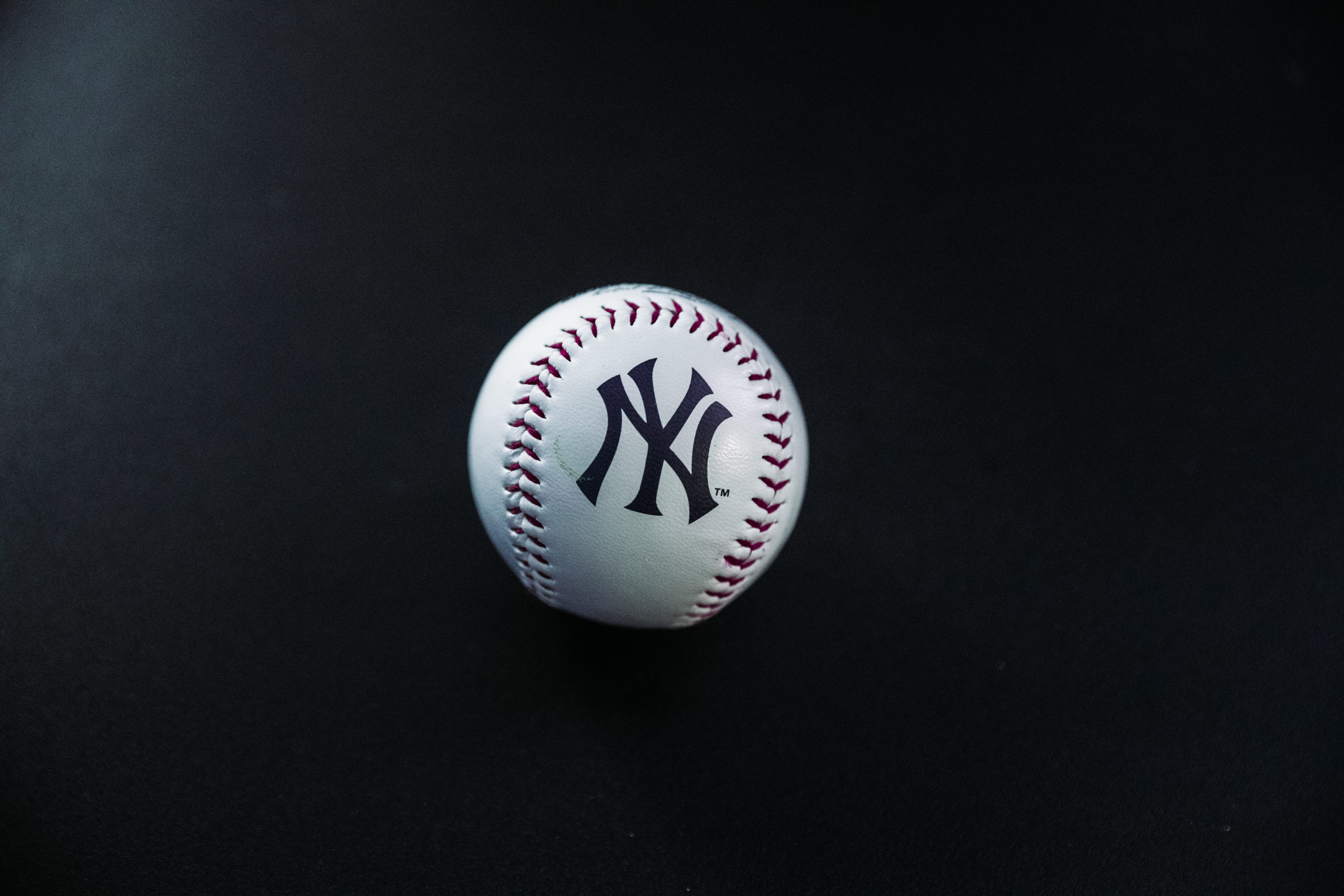 white and red New York Yankees baseball on black surface, clothing