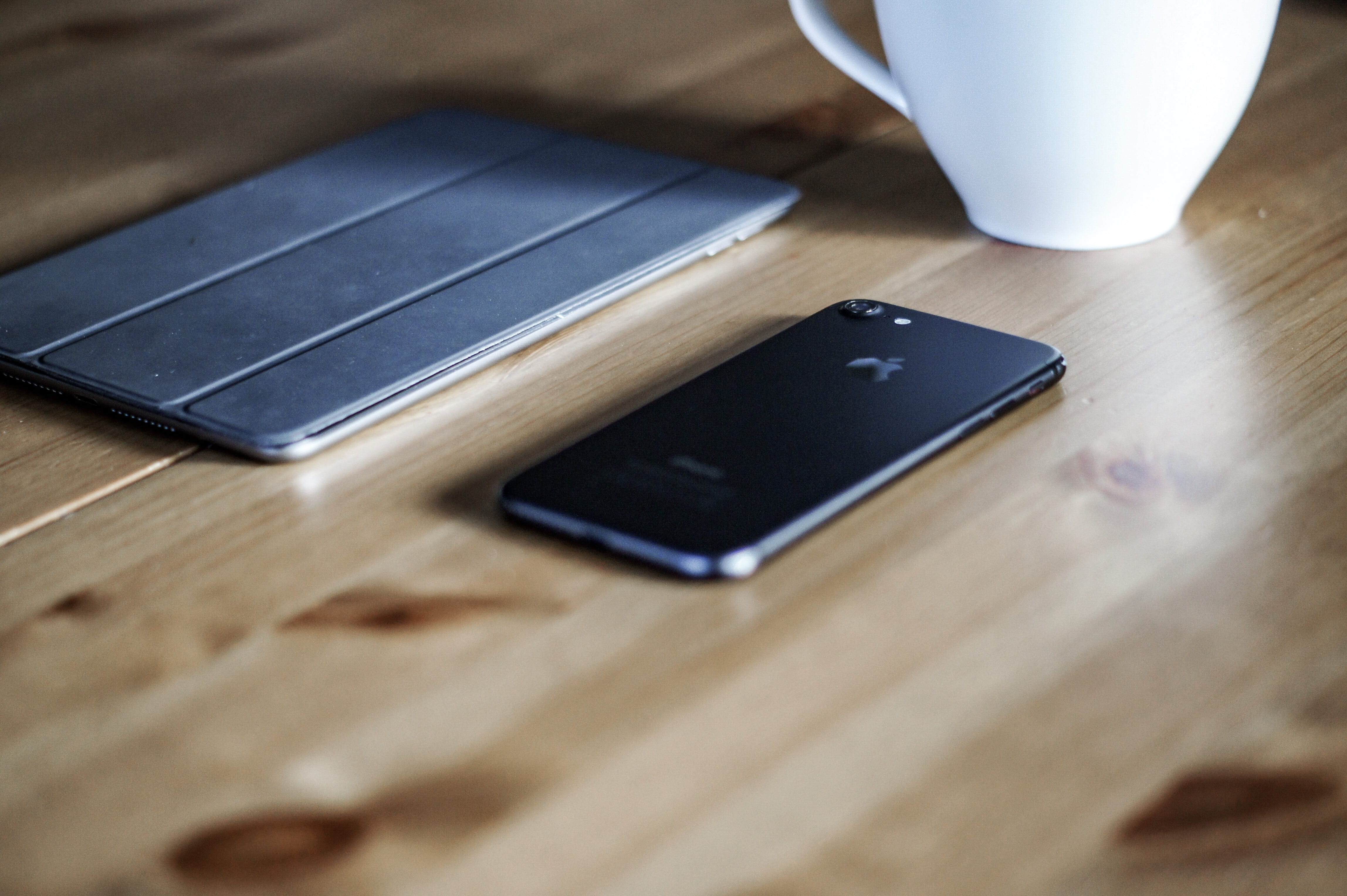 black iPhone 7 on brown surface, technology, wireless technology