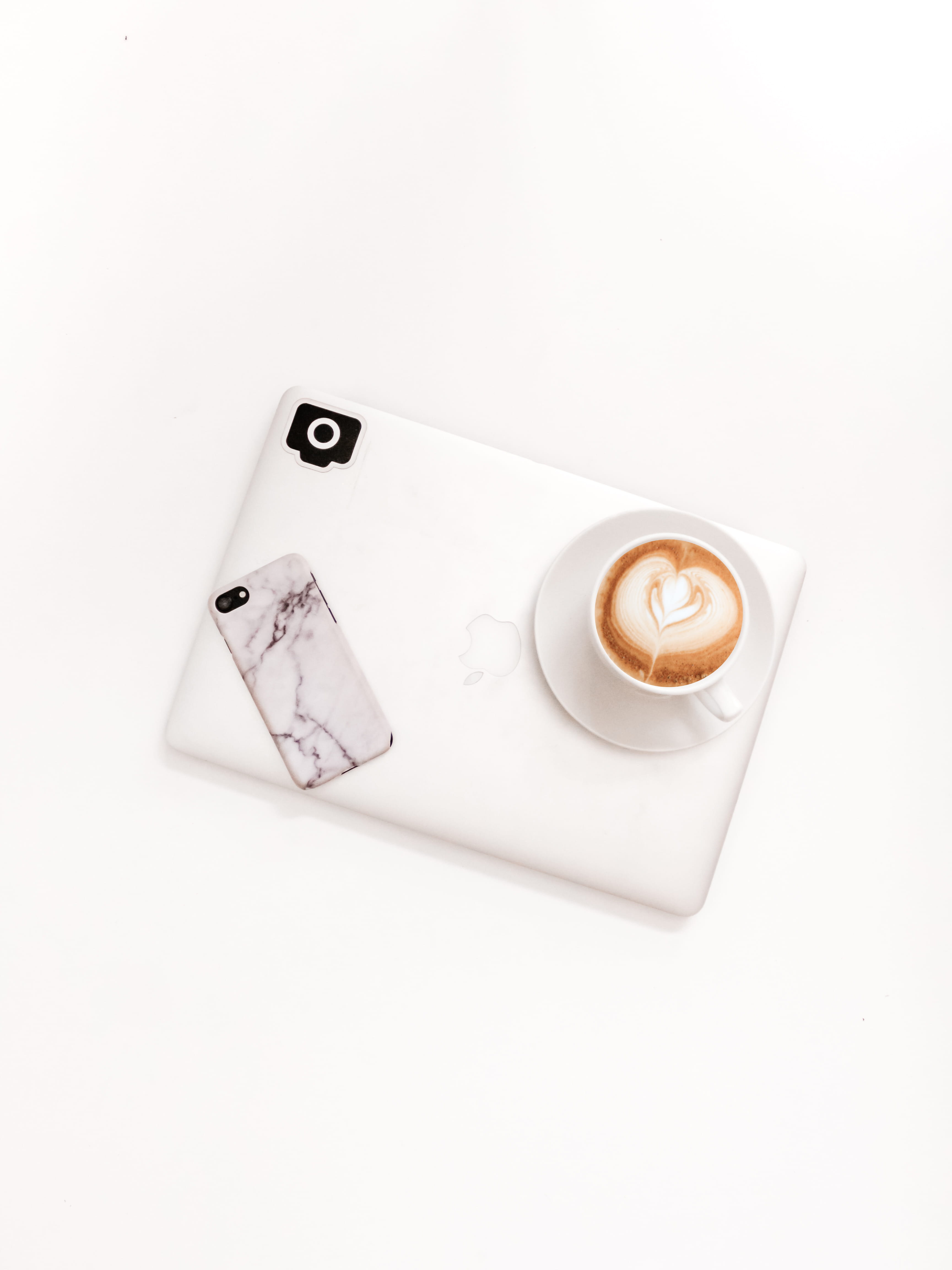 closed silver MacBook on white surface, white background, copy space