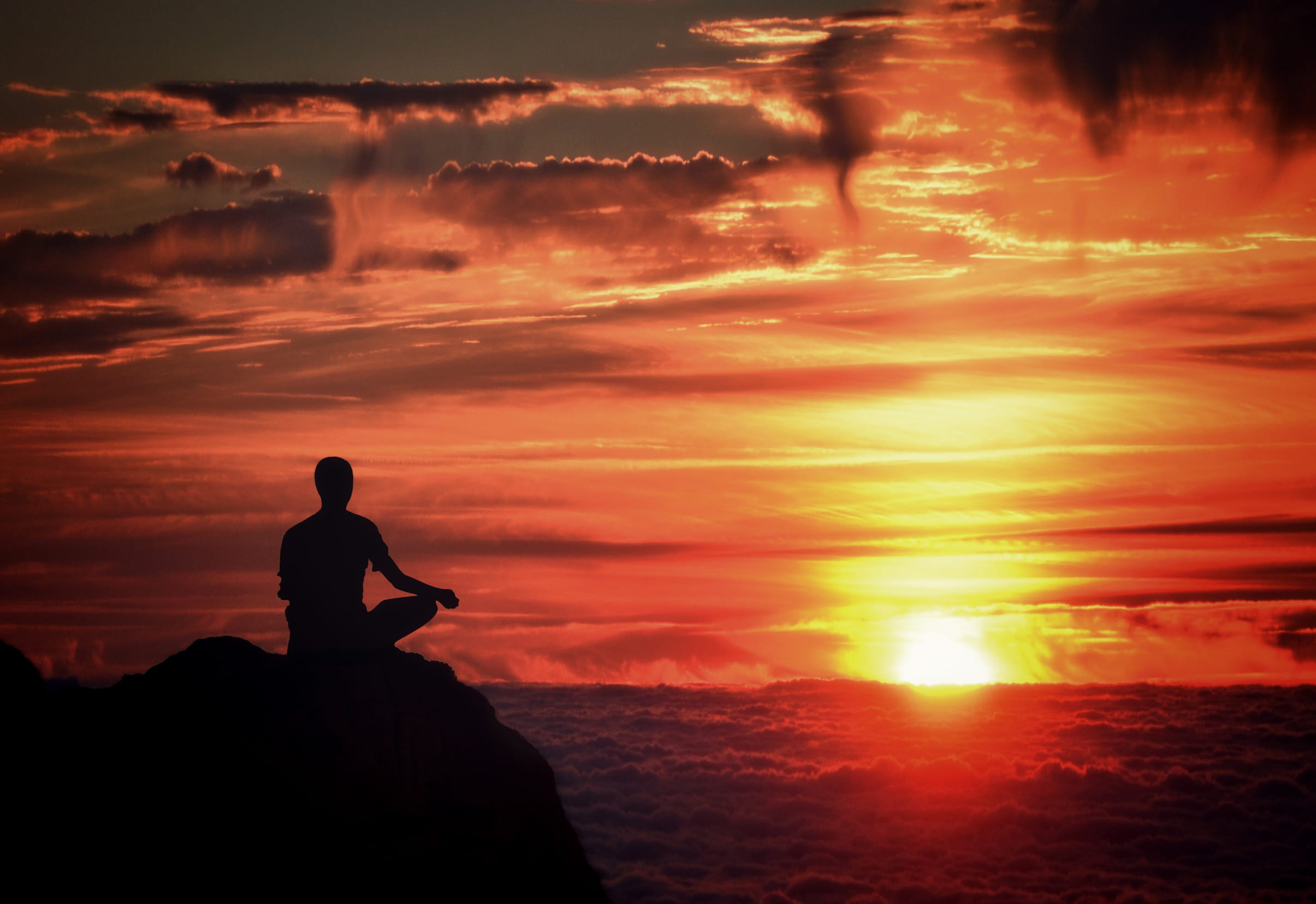 Meditation - Mindfulness - Person Meditating at Sunset Over the Clouds