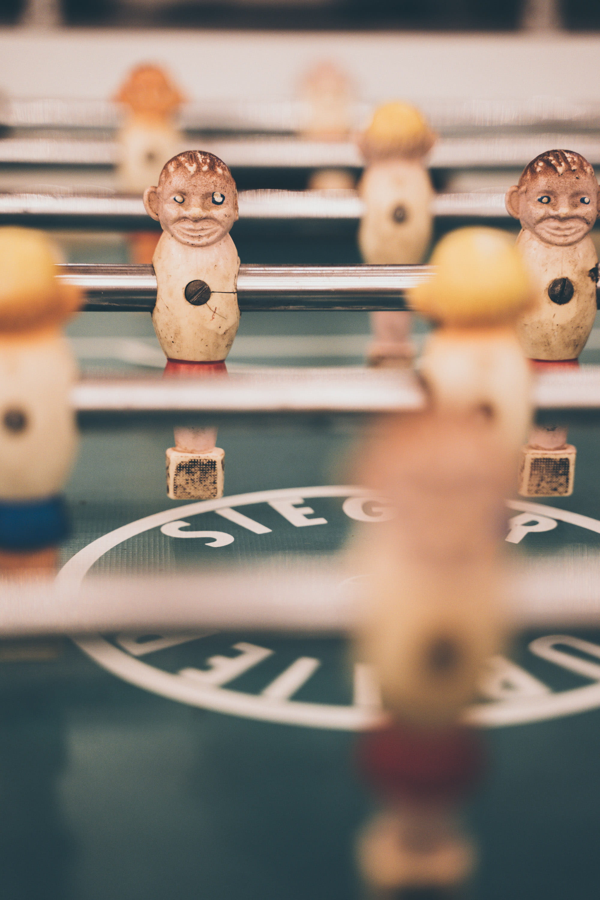 foosball table, human representation, indoors, selective focus