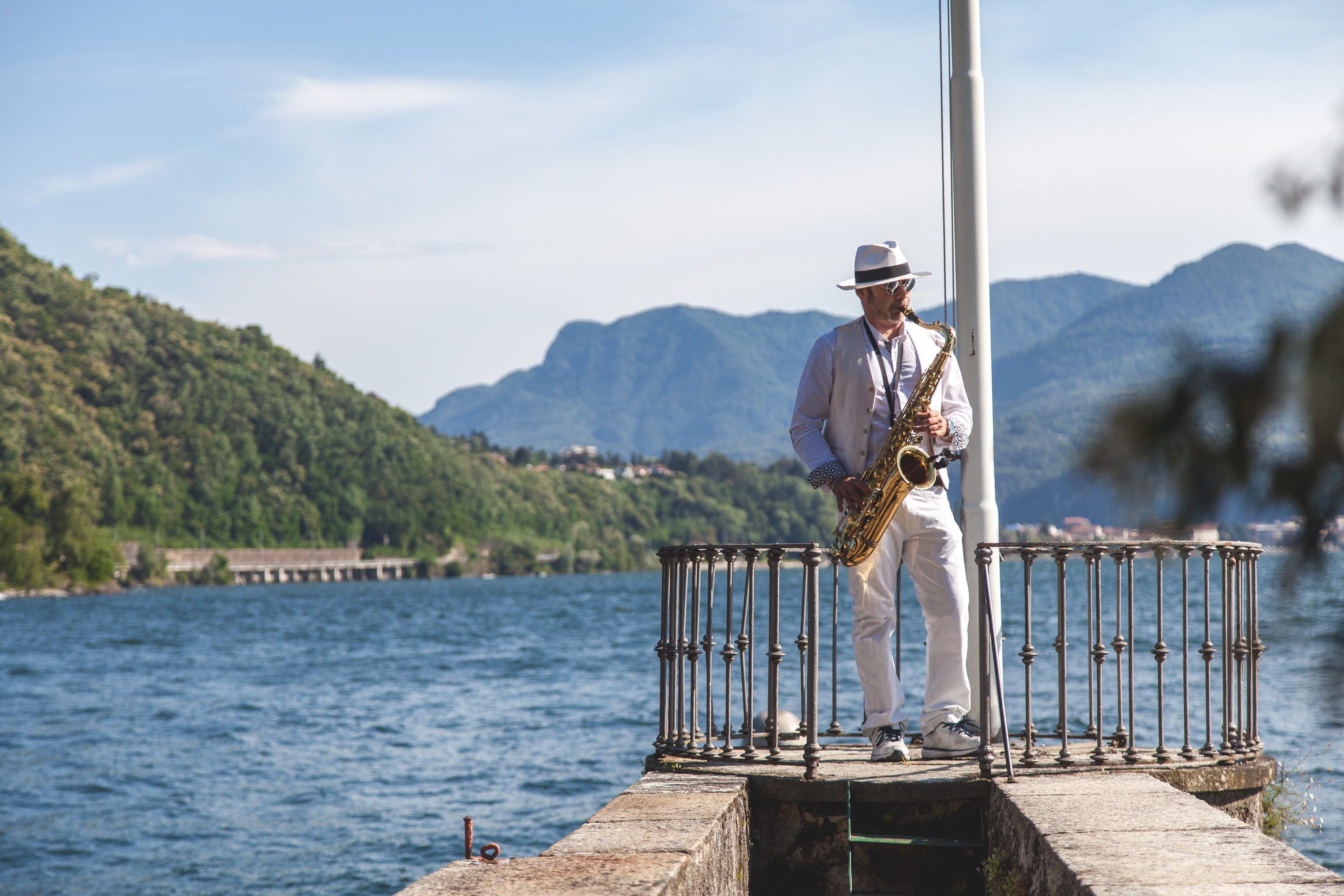 Man Playing French Horn on Dock, adult, daylight, landscape, leisure