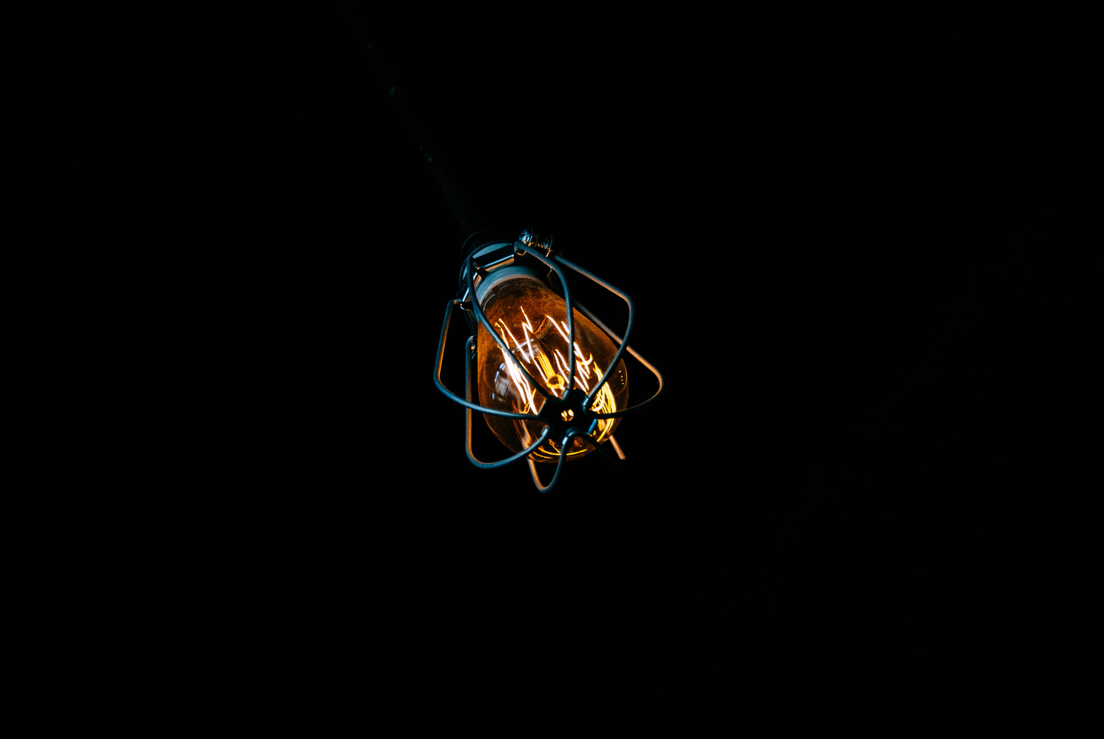 lighted light bulb, copy space, black background, studio shot