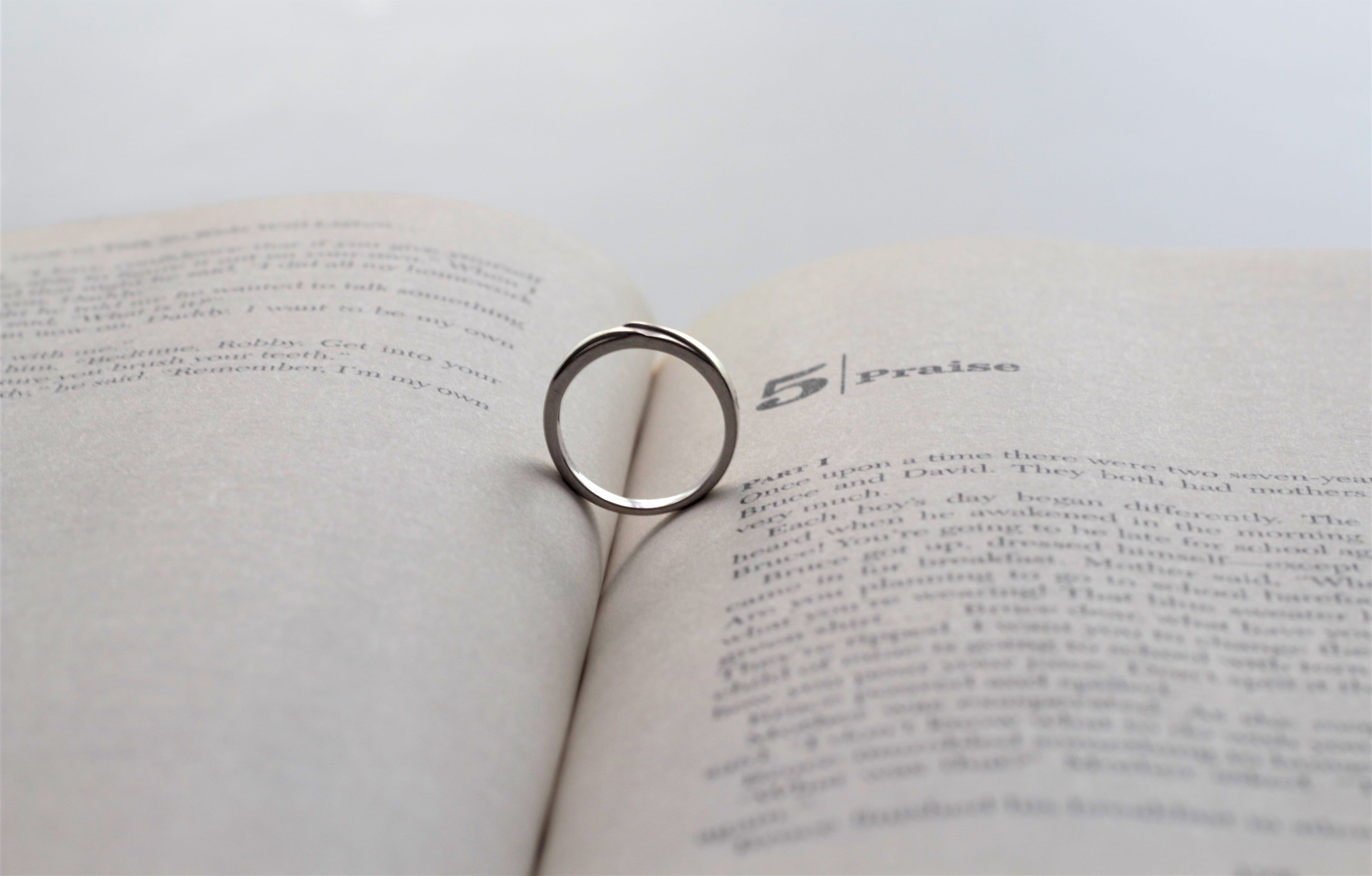 silver-colored ring on opened book, paper, wedding, wedding ring