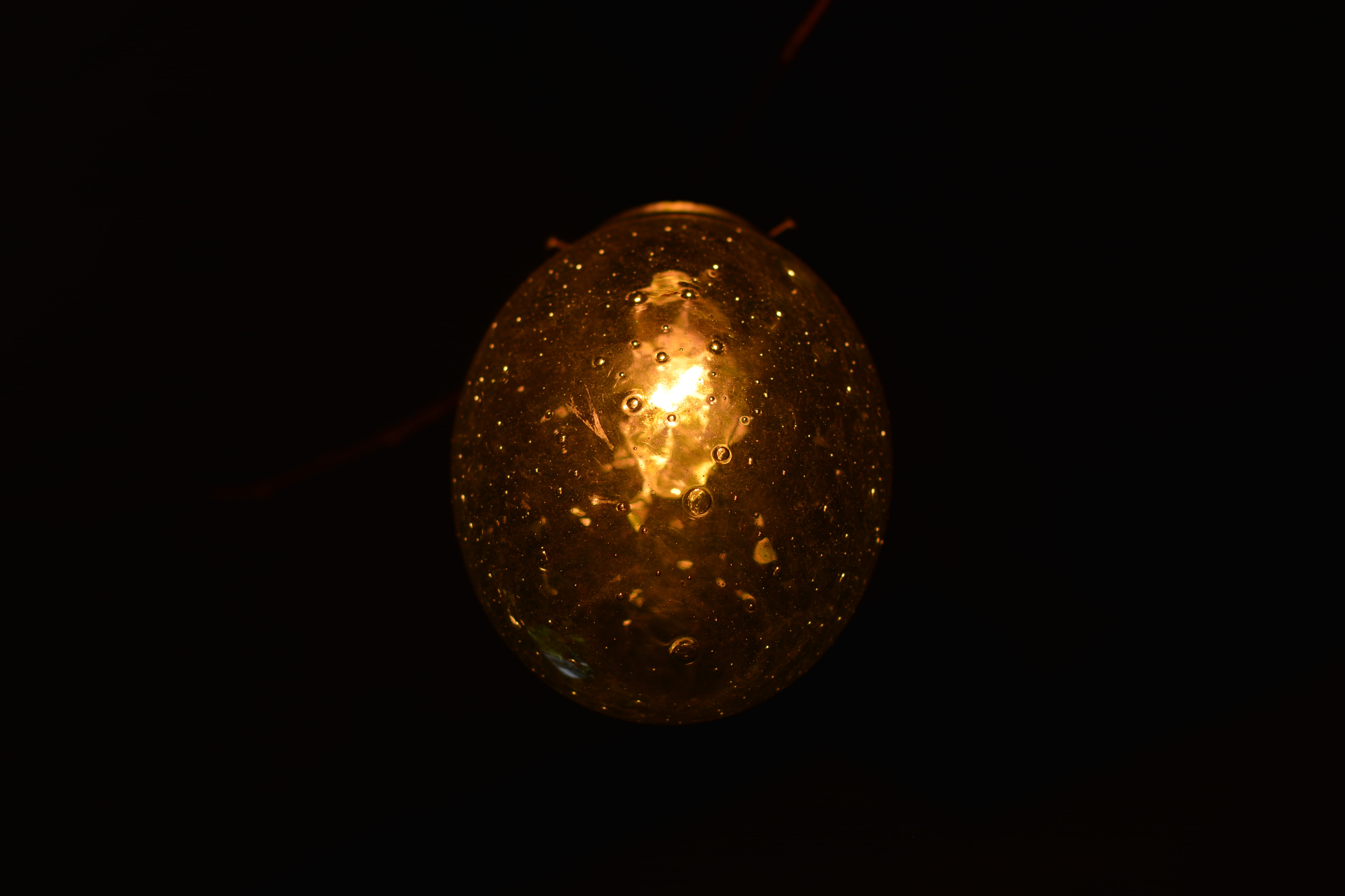 light bulb, dark, black background, no people, single object