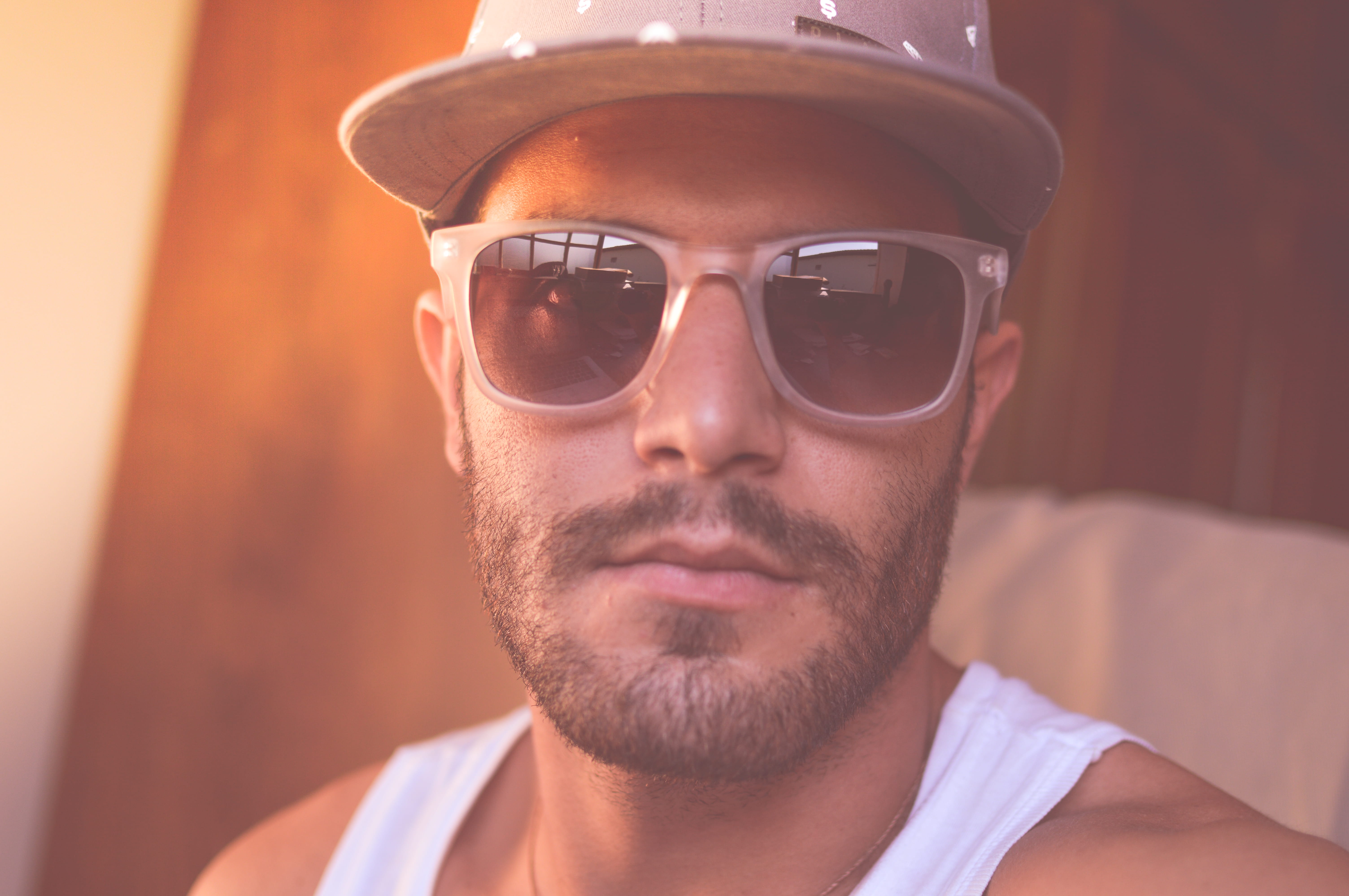 Man Wearing White Tank Top and Sunglasses Taking Close-up Selfie