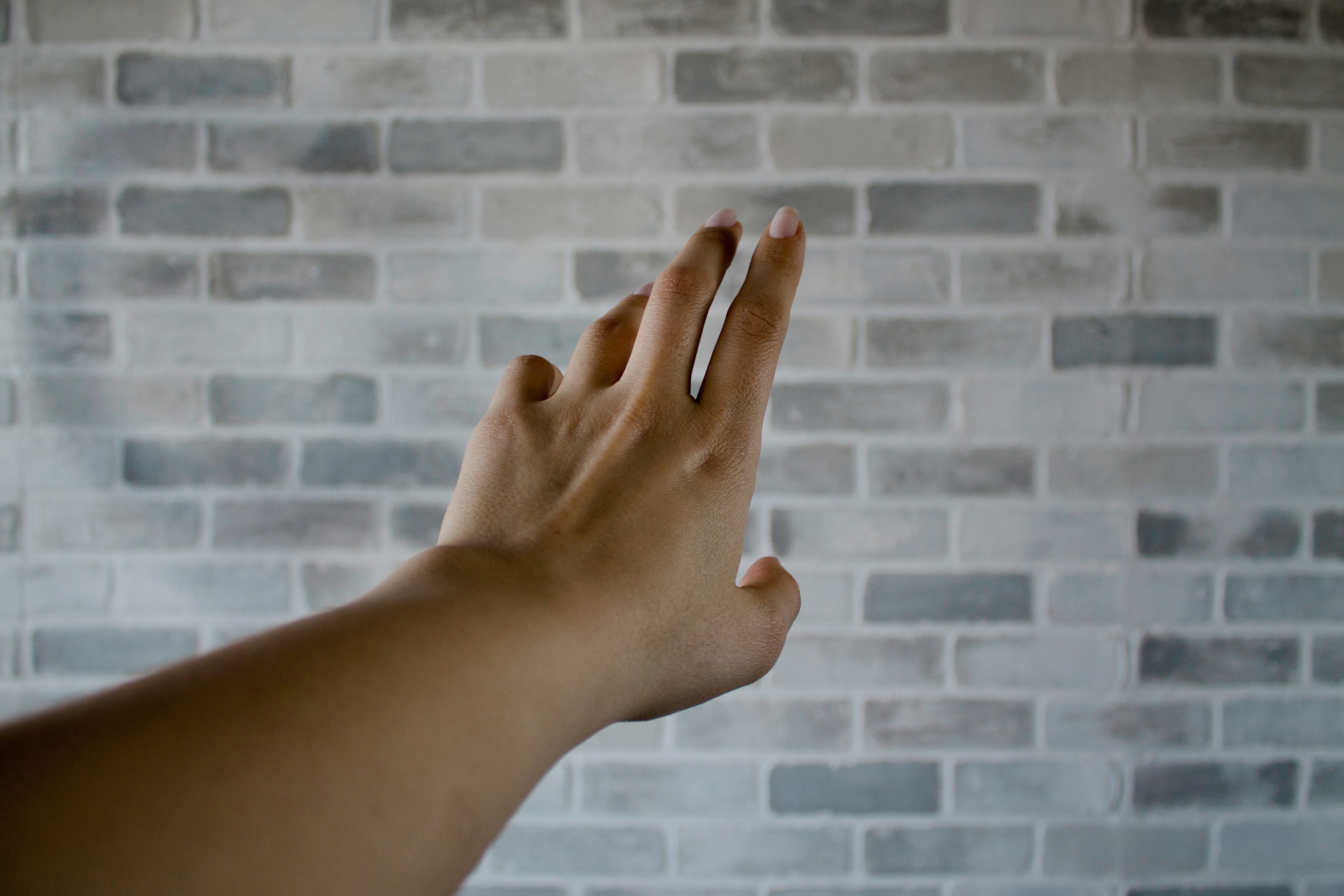 Person's Left Hand Near Gray Cinder Bricks, arm, brick texture