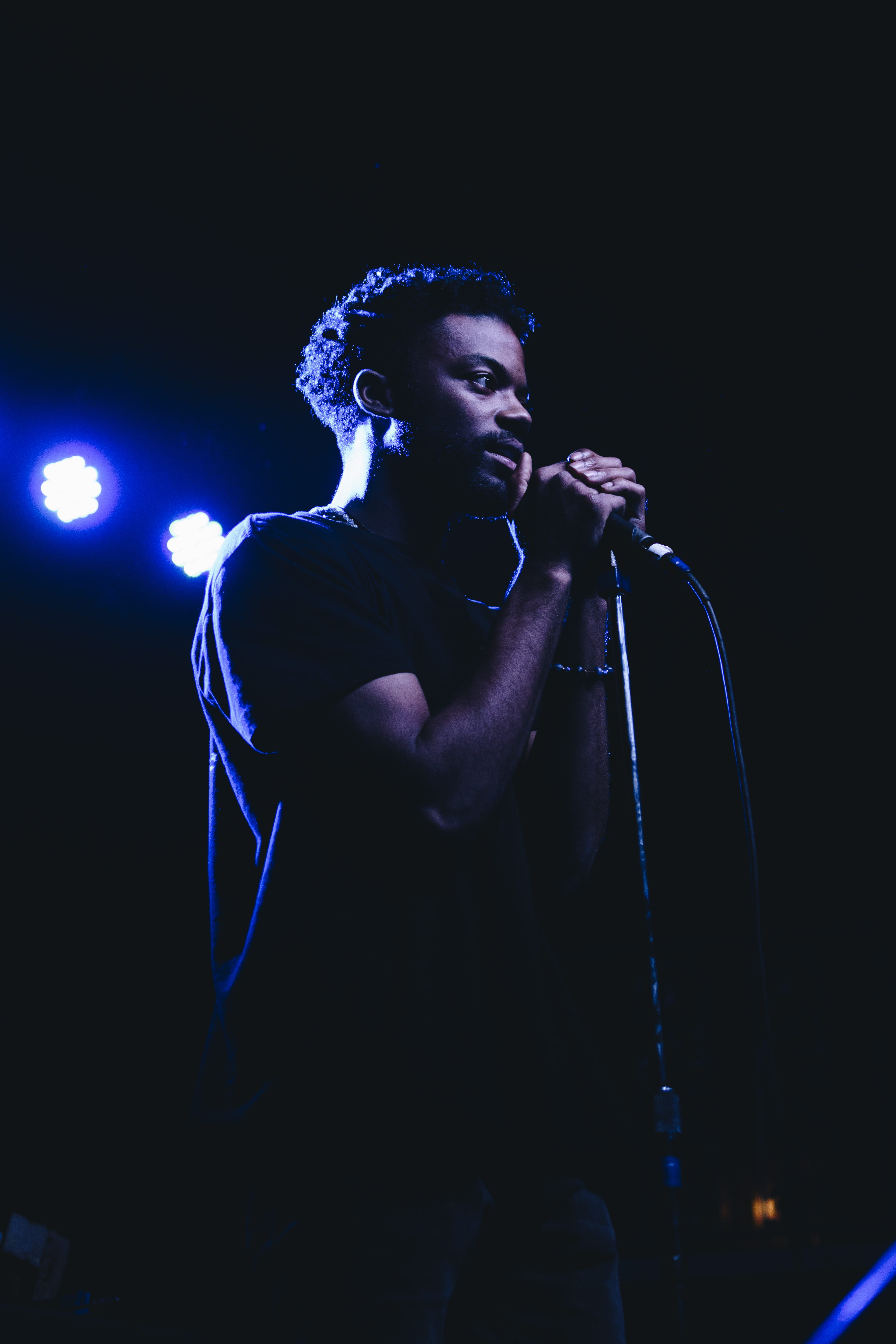 man standing while holding microphone, input device, singing
