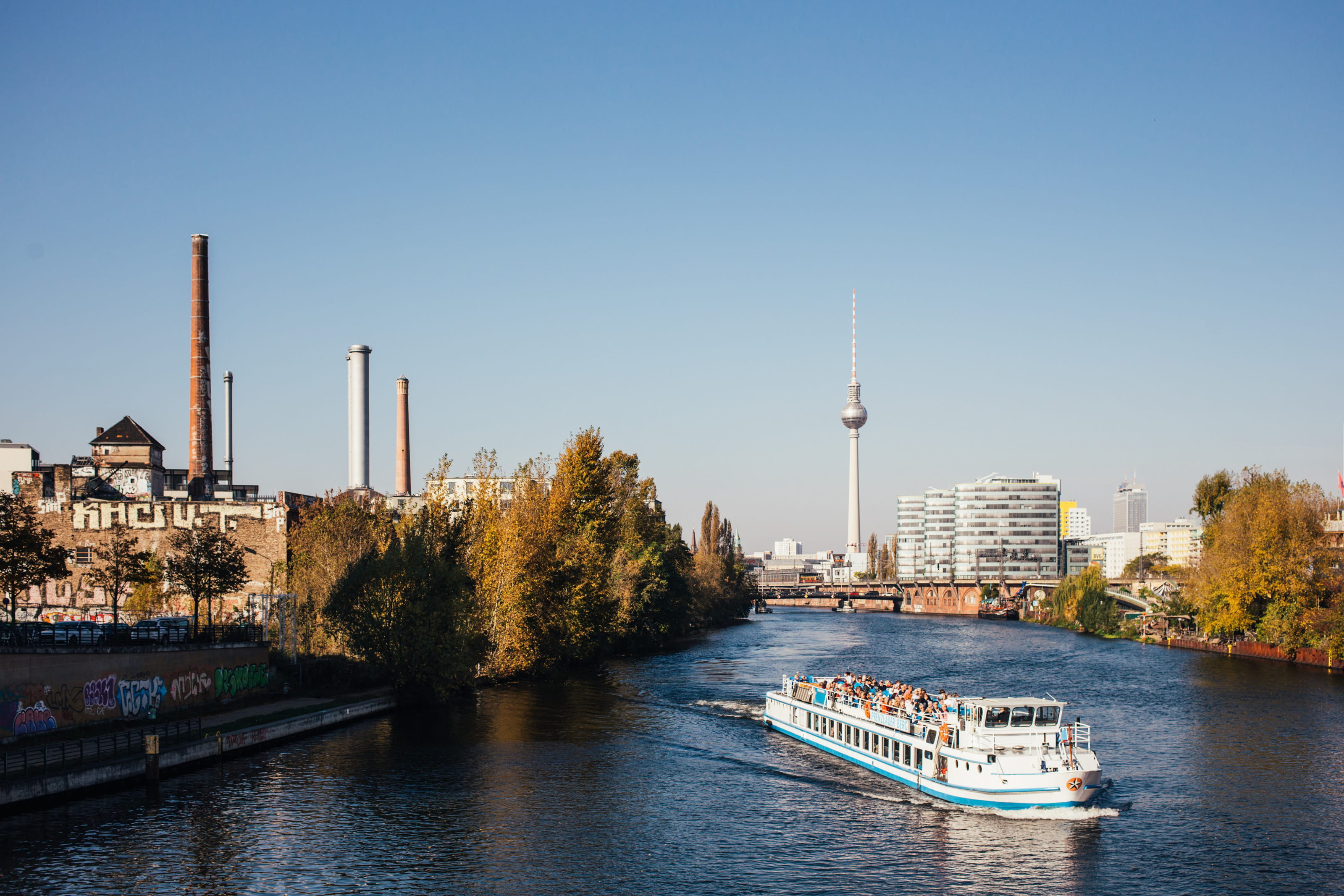 Boat in a river in Berlin with city buildings in the background