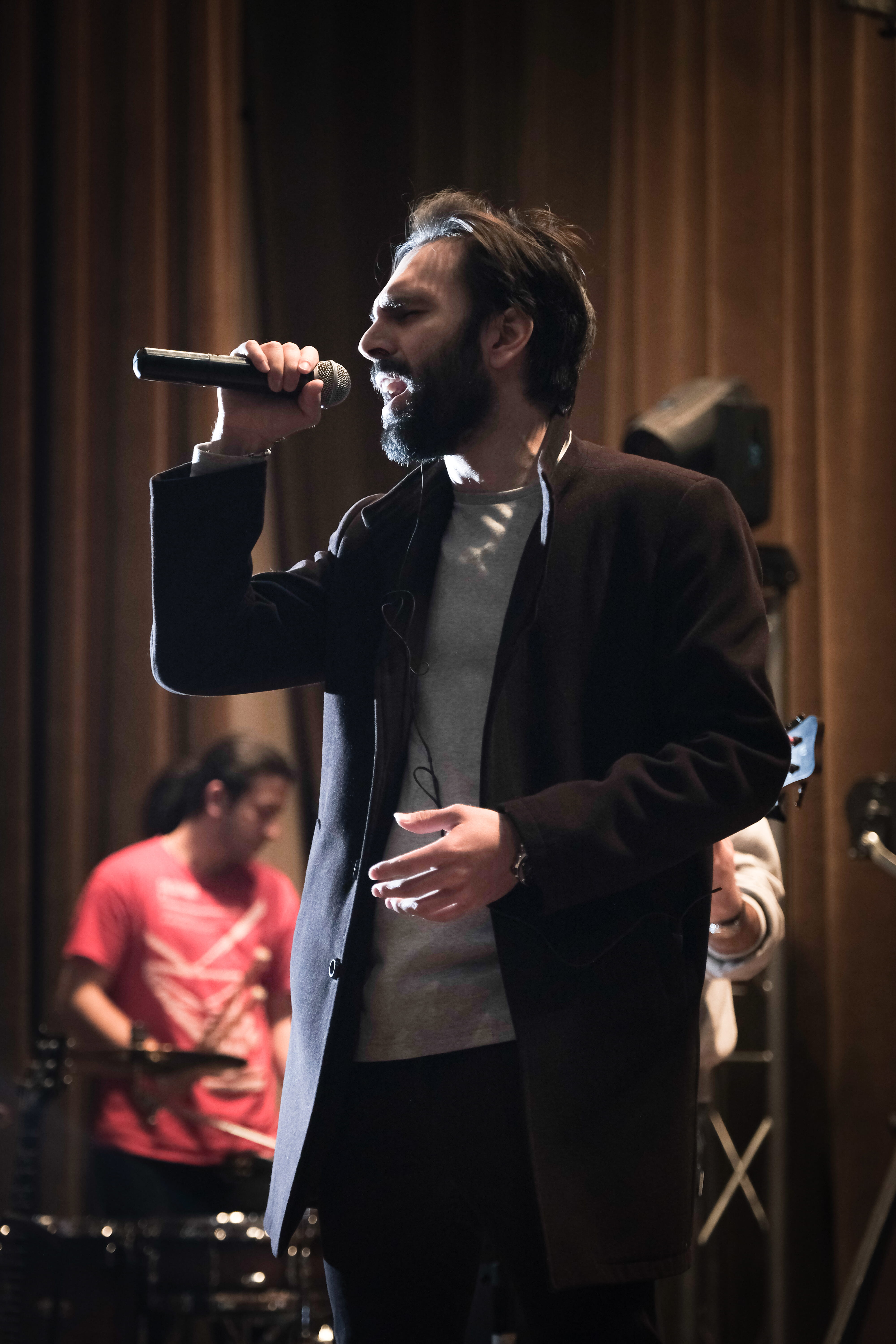 man singing while holding microphone, standing, input device
