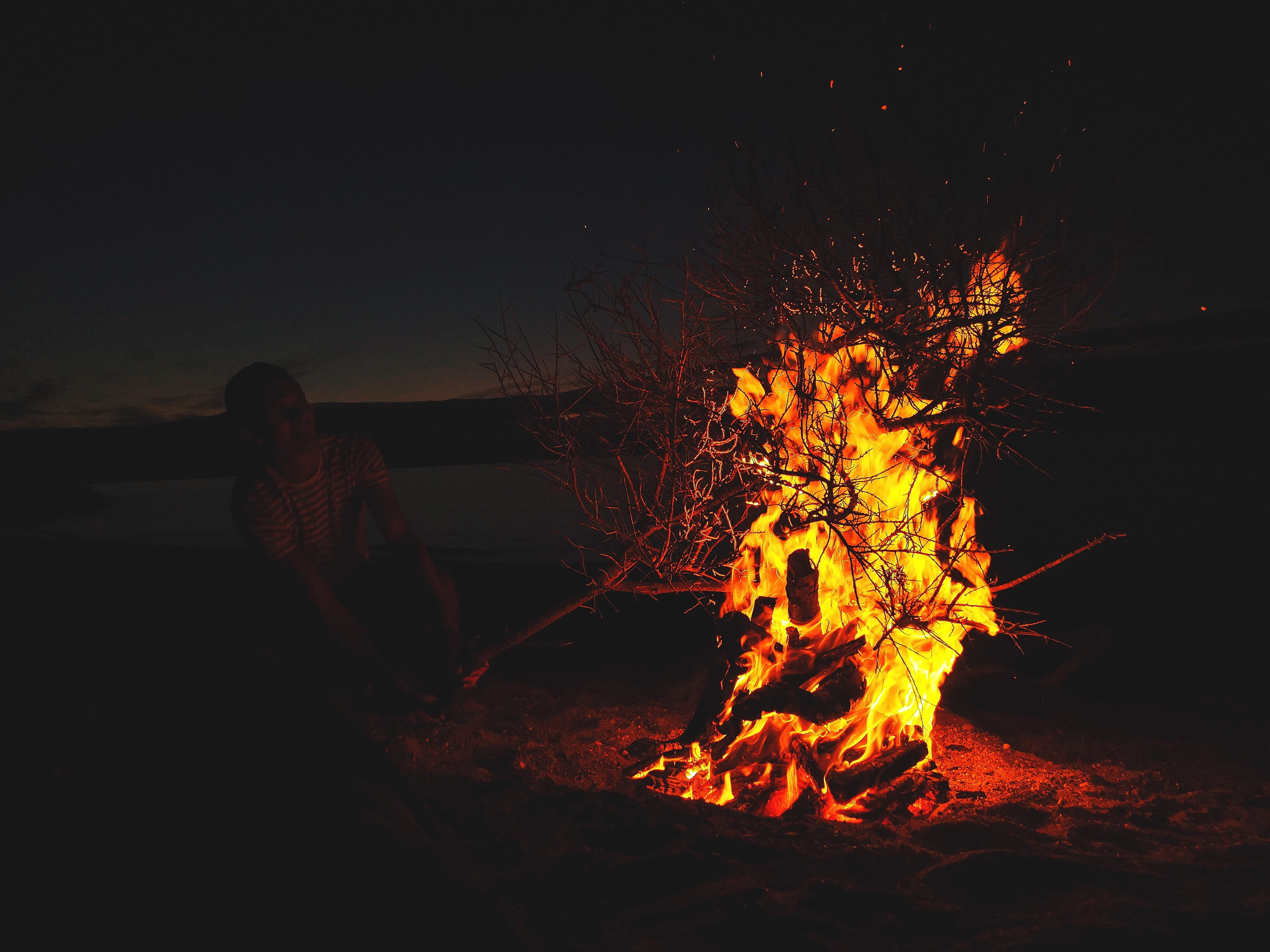 man in front of lighted bonfire, flame, fire flame, fire pit