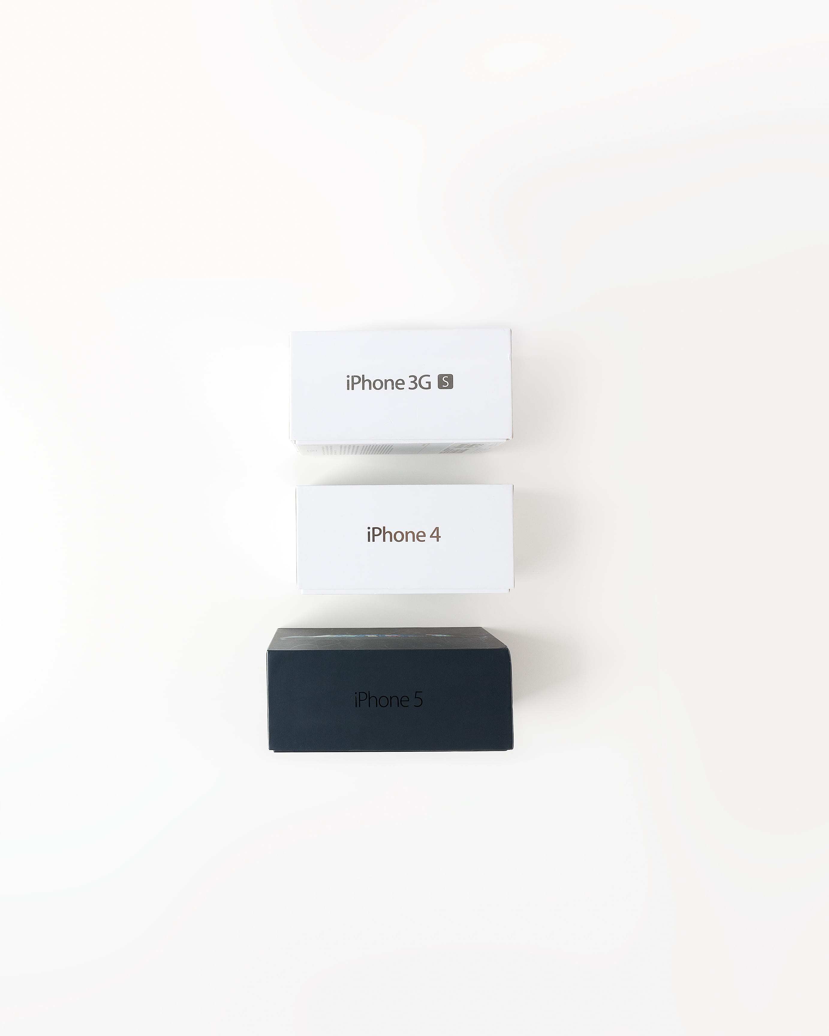 assorted iPhone boxes on white surface, studio shot, white background