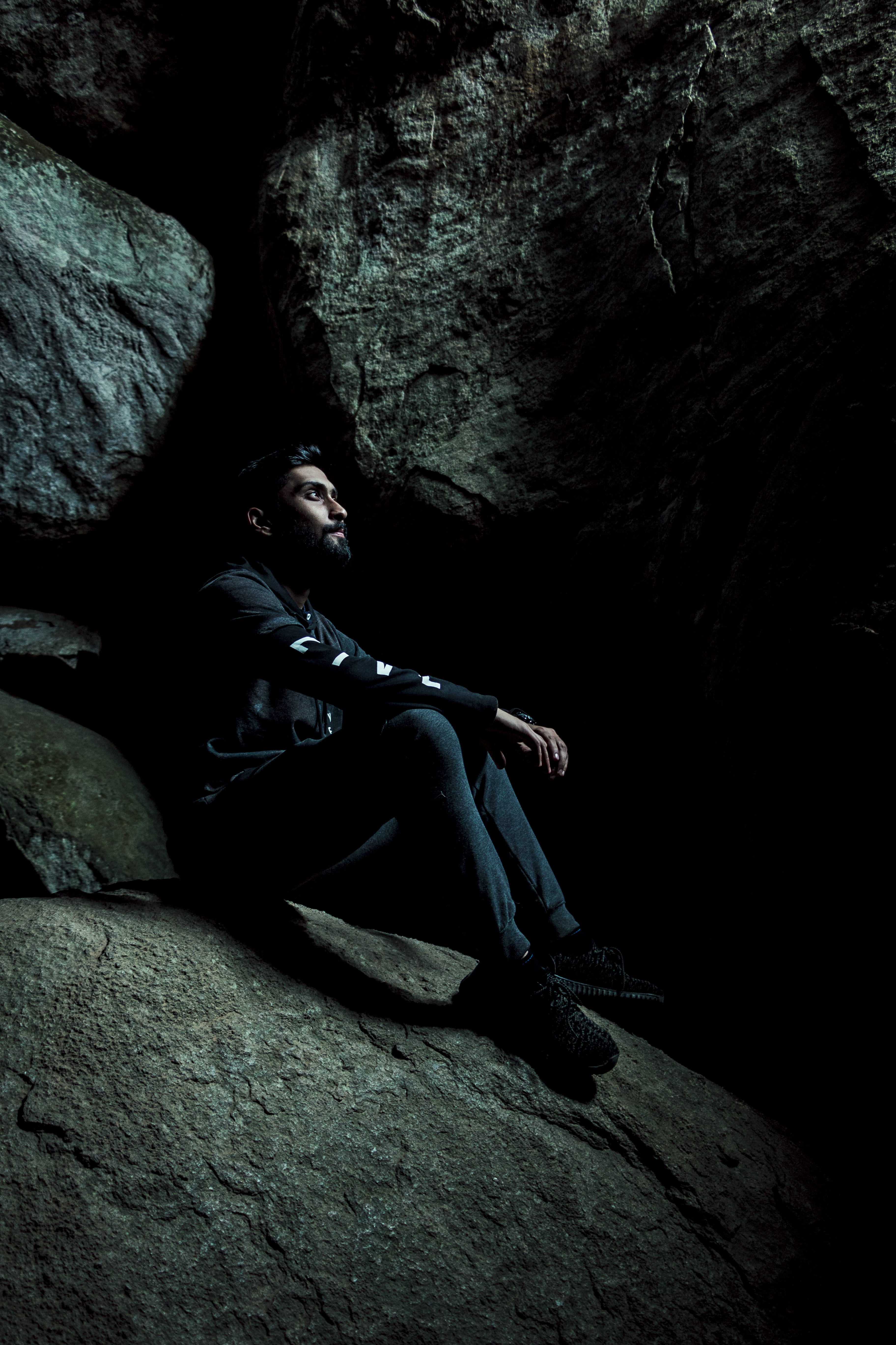 man sitting inside cave, rock, rock - object, solid, full length