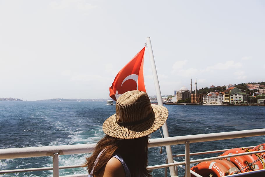 Woman Wearing Brown Sun Hat Near Turkey Flag and Body of Water HD wallpaper