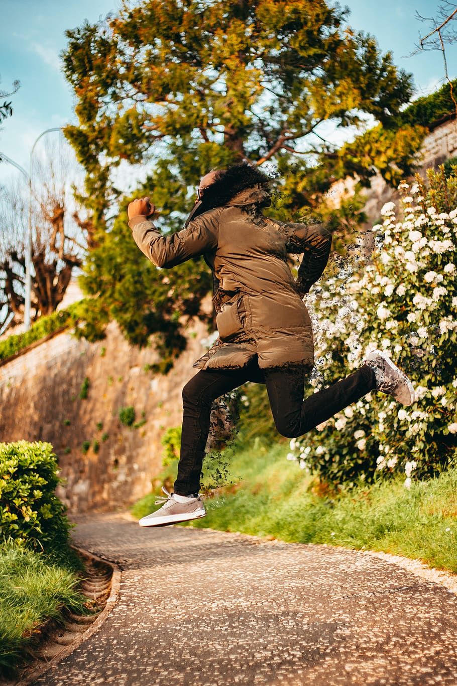 Person in Gray Coat Jumping on Gray Concrete Pathway, active HD wallpaper