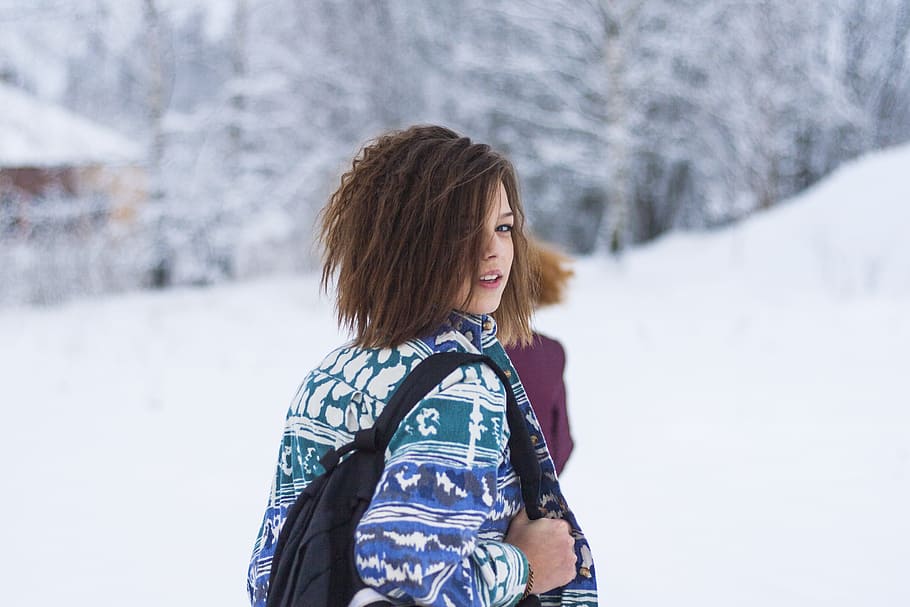 Selective Focus Portrait Photograph of Woman Wearing Blue, Green, and White Tribal Jacket and Black Backpack Outfit HD wallpaper