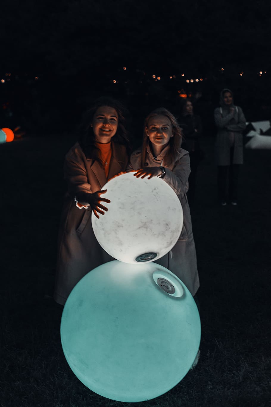 Two Women Holding Lighted Balls, dark, facial expression, group HD wallpaper