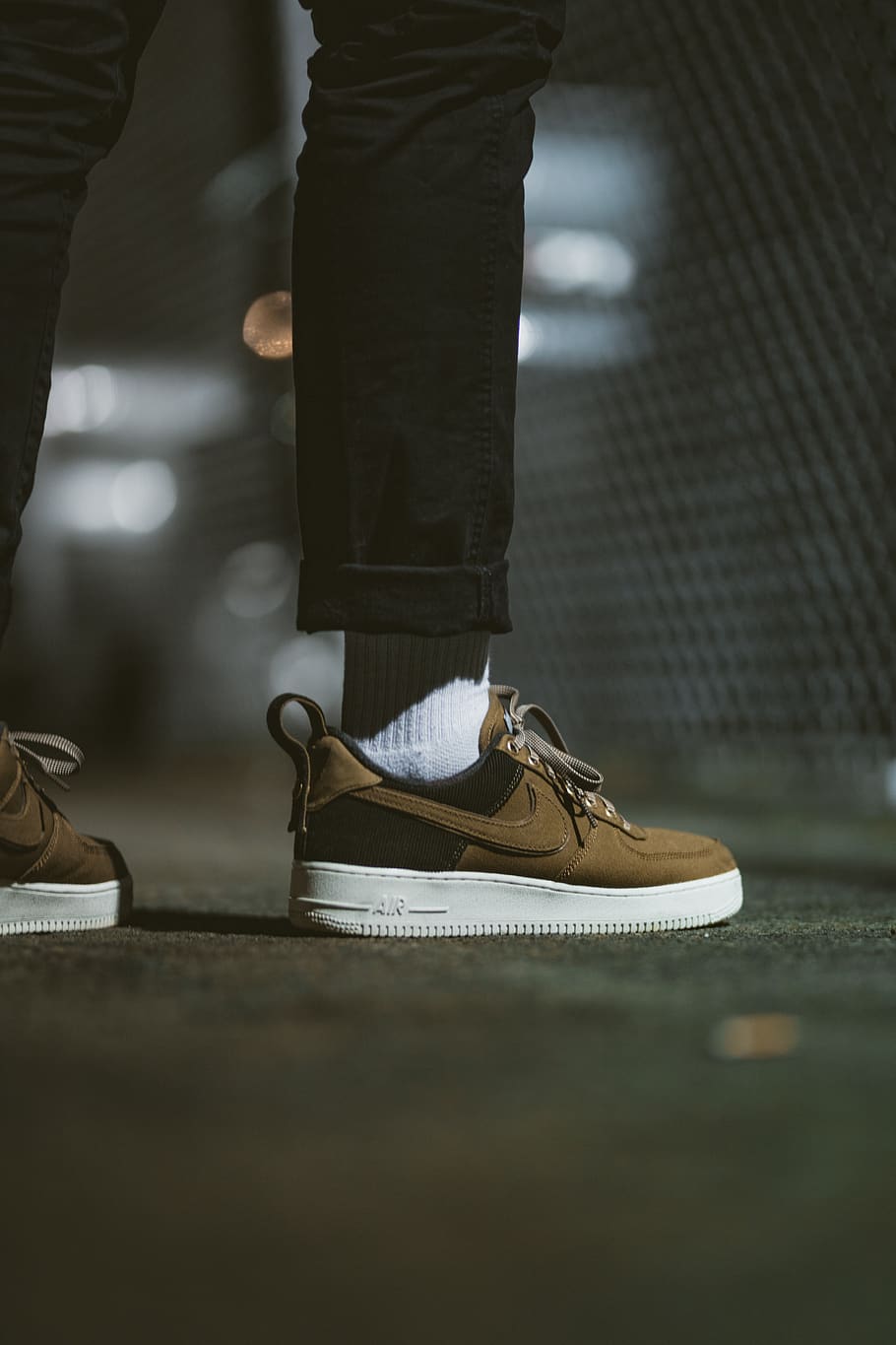 person standing wearing brown and black Nike Air Force 1, apparel