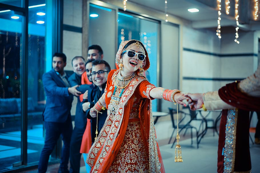 woman being pulled by men, focus on foreground, indoors, illuminated HD wallpaper