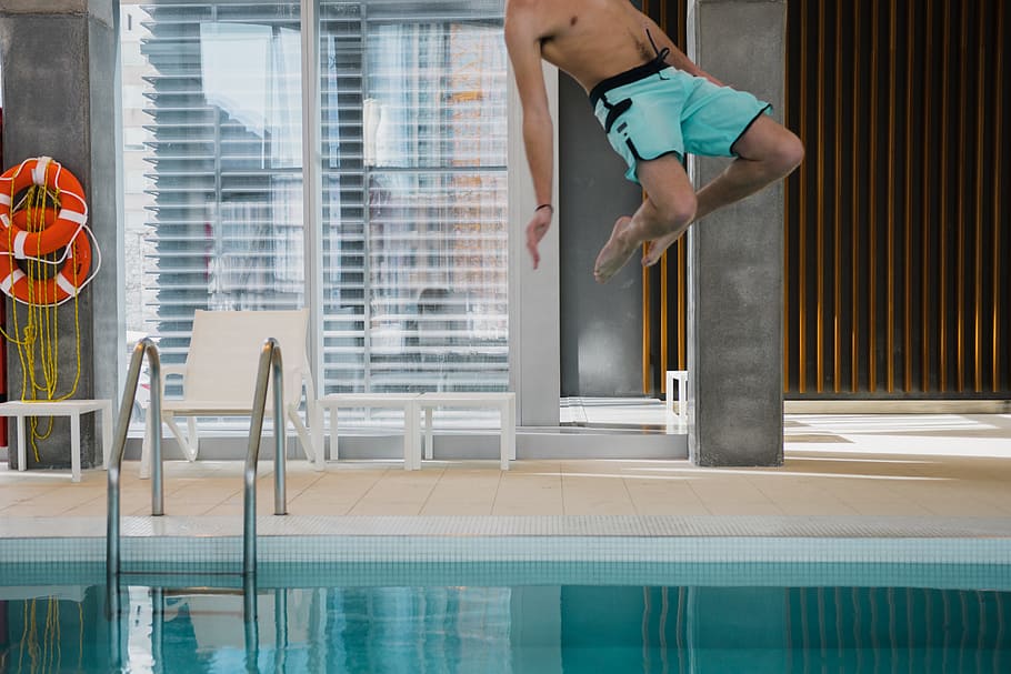 man in teal boardshorts jumping on pool, male, splash, person