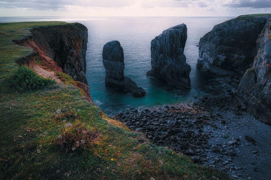sea stack beside cliff in Wales, rock, water, scenics - nature HD wallpaper