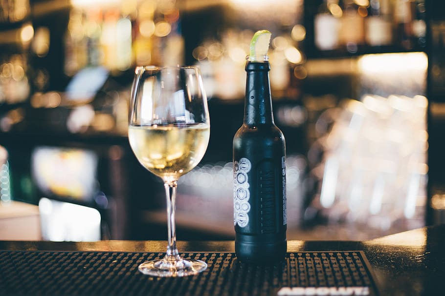 Black Bottle Beside Long-stem Wine Glass on Table, bar, counter