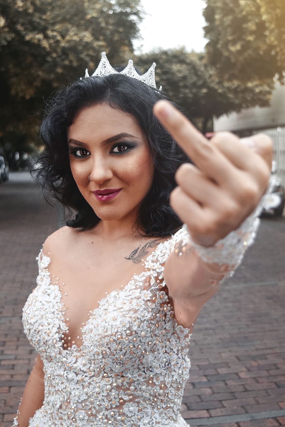 woman raising left middle finger, portrait, looking at camera