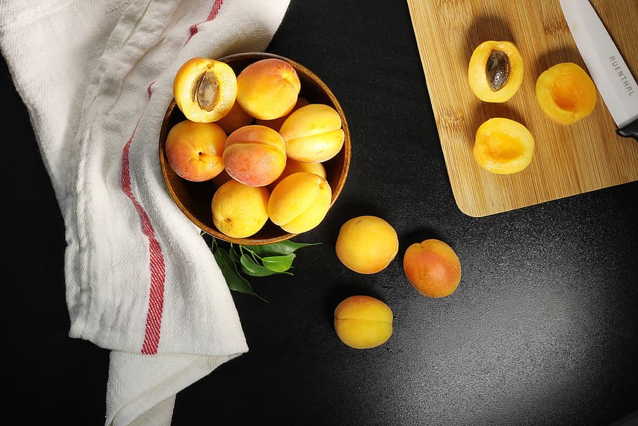 Overhead Shot Of Fresh Apricots Being Halved And Pitted Photo
