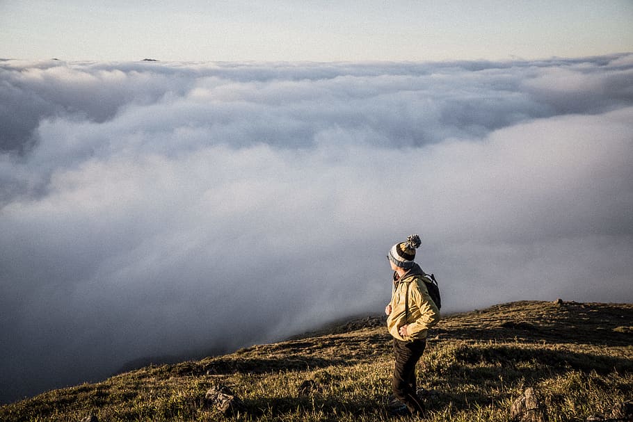 Man Standing on Top of Moutain, backpack, bonnet, clouds, daylight HD wallpaper