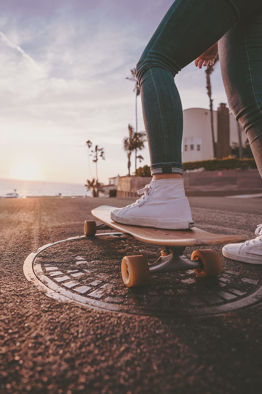 woman riding skateboard during daytime, palm tree, street, sunset