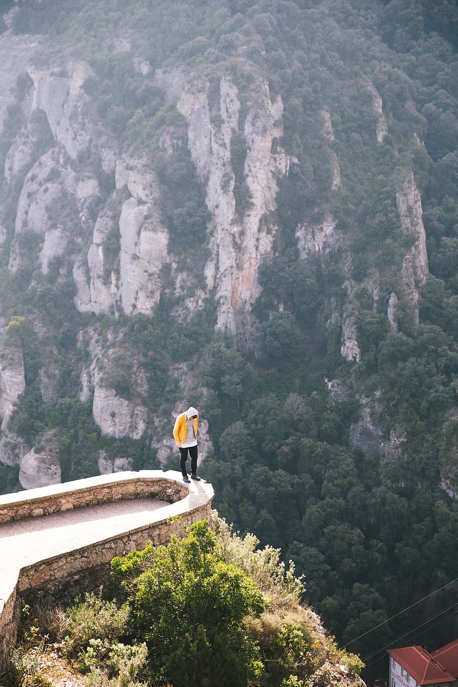 A hiker standing on the edge of a viewing platform in Montserrat, a mountain range in Spain, HD wallpaper