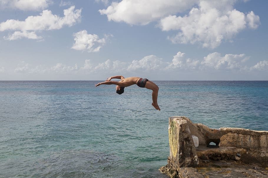 man jumping on clif, sky, sea, water, one person, full length HD wallpaper