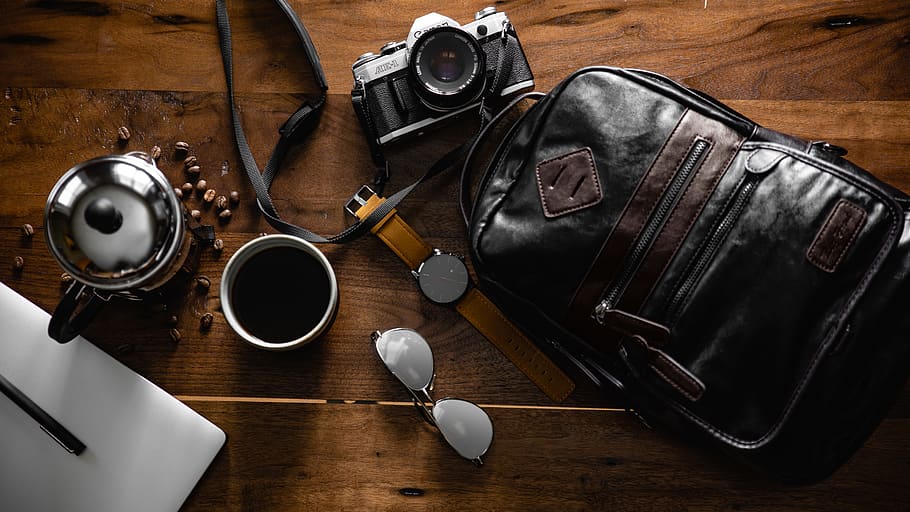 Flat Inlay Photography of Black Leather Backpack, Camera, Watch and Cup of Coffee HD wallpaper
