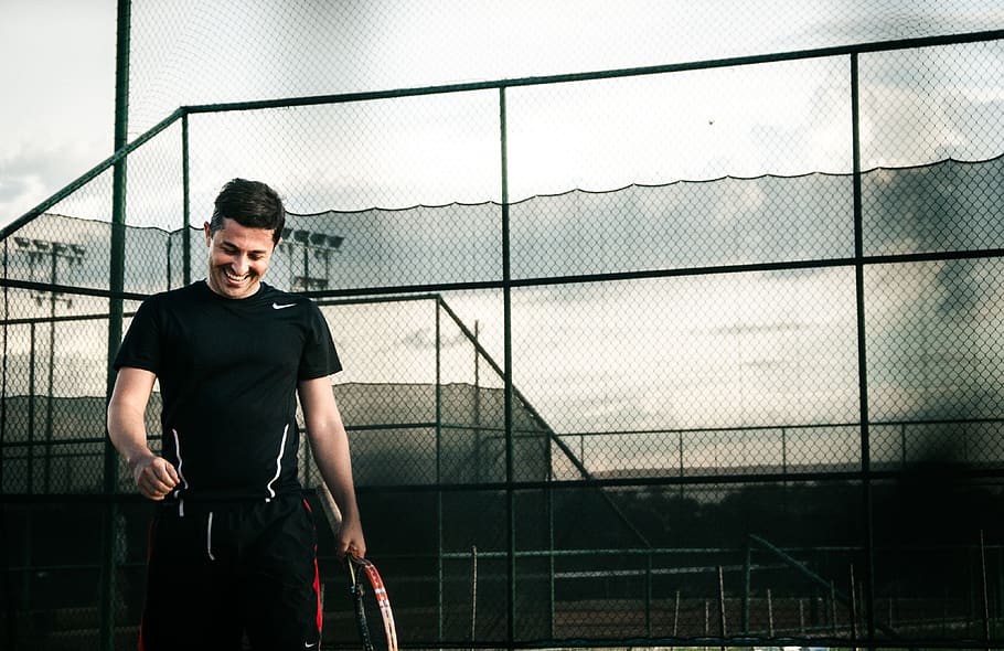 Man Wearing Black Nike Dri-fit Shirt Holding a Tennis Racket