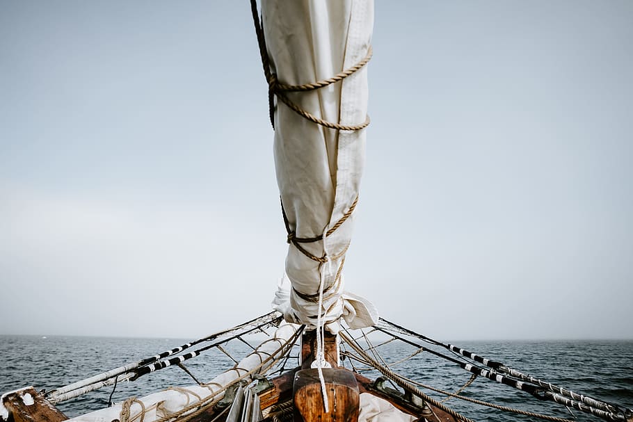 boat on sea under white sky, sail, mast, ocean, rope, tied, horizon