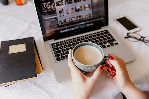 A woman works at a desk with a laptop and a cup of coffee, macbook HD wallpaper