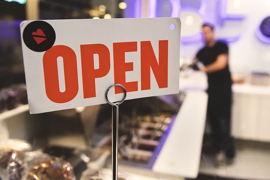 Shallow Focus Photography of Red and White Open Signage Near Man Wearing Black Shirt HD wallpaper
