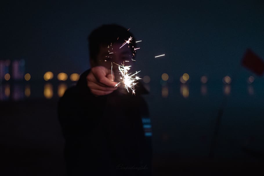 man holding fireworks, person, human, light, flare, finger, hand HD wallpaper