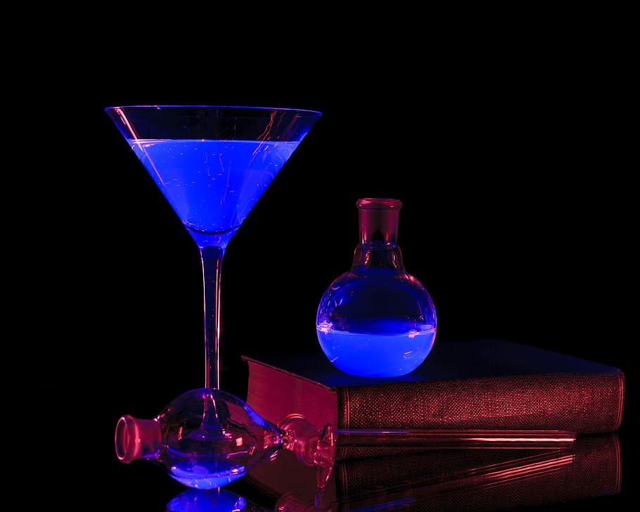 Chemical solutions producing blue and red colors under a black light.
