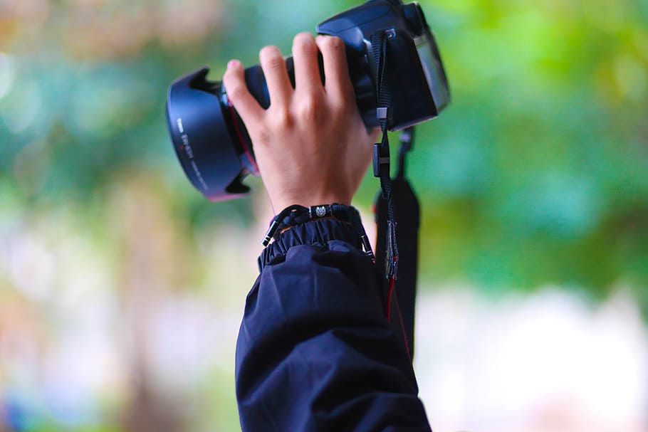 Person Holding Black Dslr Camera, blur, close-up, hand, looking HD wallpaper