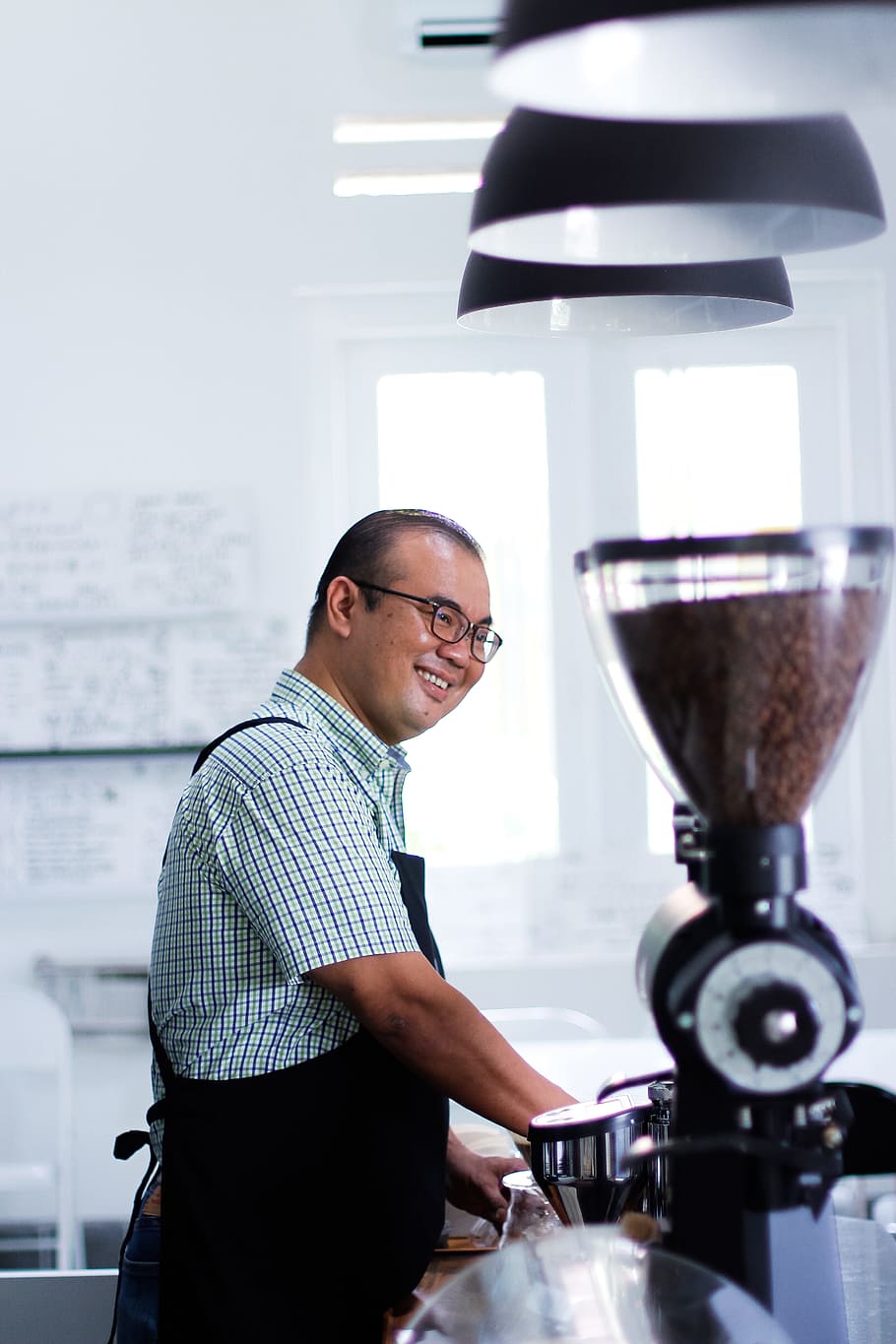 Man Wearing Plaid T-shirt And Black Apron in Front of Coffeemaker HD wallpaper