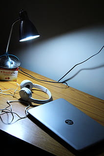 Gray Hp Laptop and White Corded Headphones on Brown Wooden Table HD wallpaper